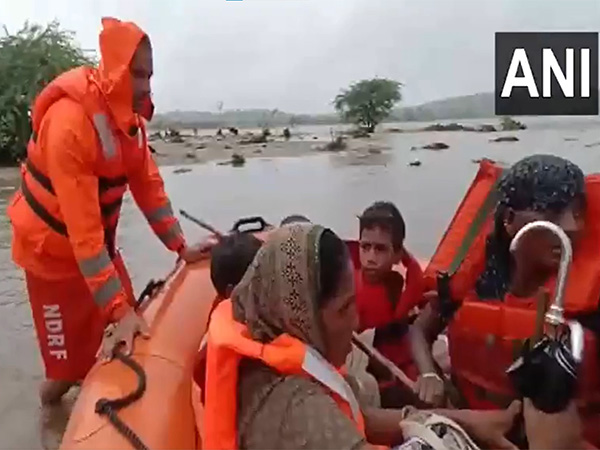 SDRF team rescues 9 people stranded in flooded Sabarmati River near Danta. (Photo/ANI) SDRF team rescues 9 people stranded in flooded Sabarmati River near Danta. (Photo/ANI)