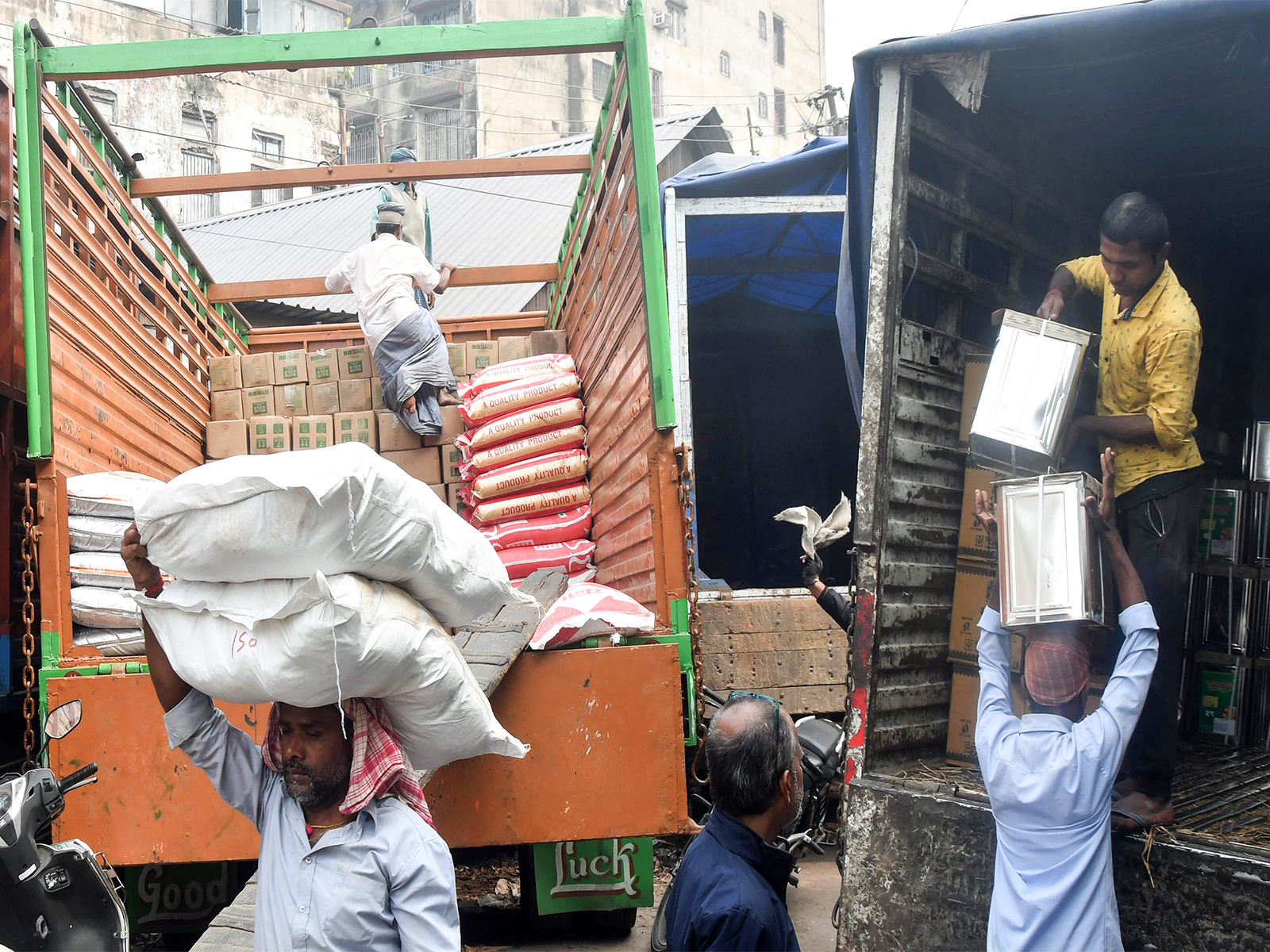 Labourers load the sacks of food items to a truck in a wholesale market (Photo/ANI) Labourers load the sacks of food items to a truck in a wholesale market (Photo/ANI)