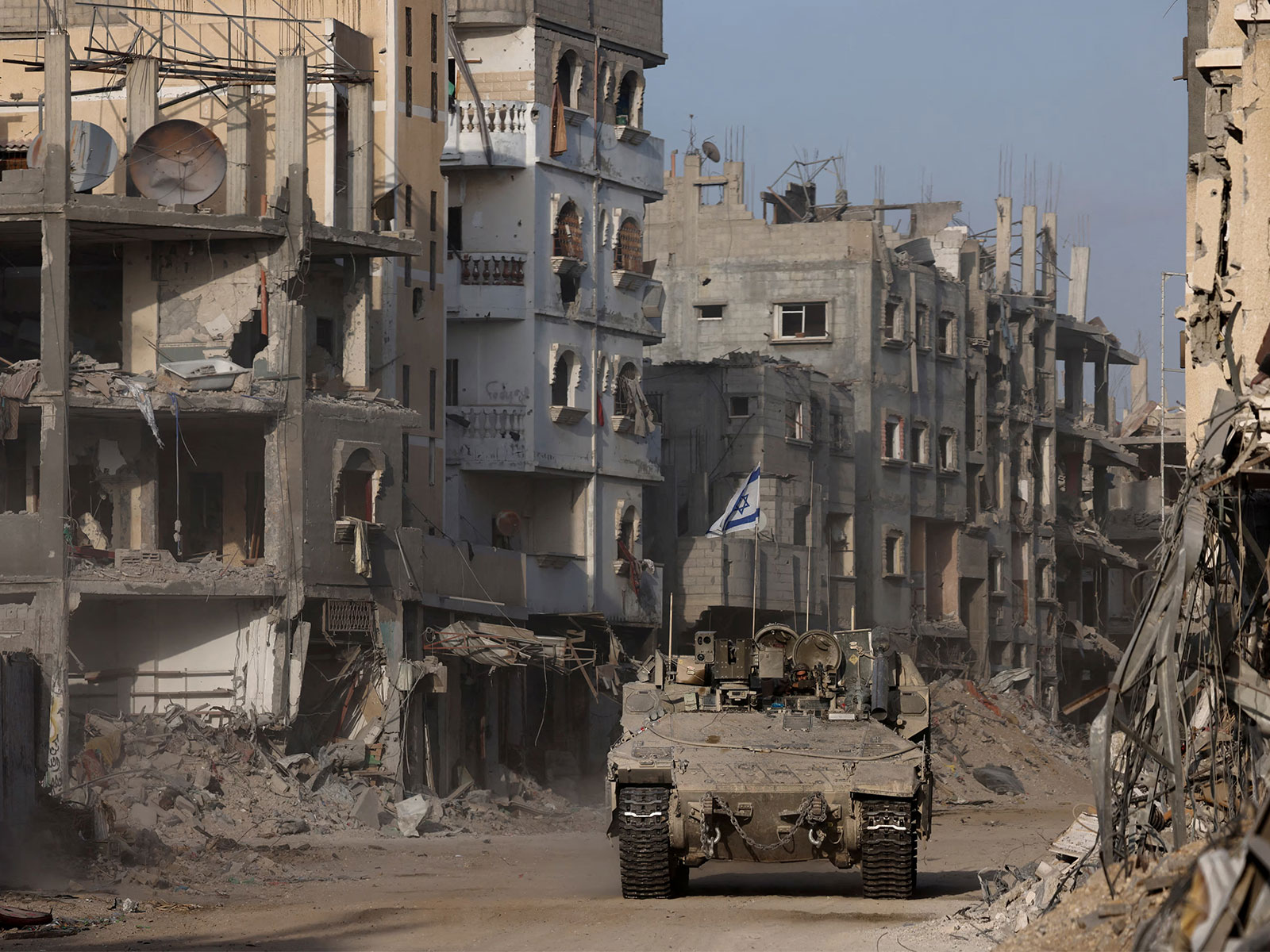 An armoured vehicle moves past damaged buildings during the ongoing Israeli ground operation against Hamas in the Gaza Strip (File Photo/Reuters) An armoured vehicle moves past damaged buildings during the ongoing Israeli ground operation against Hamas in the Gaza Strip (File Photo/Reuters)