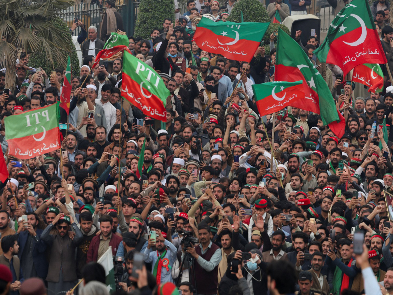 Supporters of Imran Khan’s PTI wave flags during a protest demanding free and fair election results, in Peshawar, Pakistan. (File Photo/Reuters)
