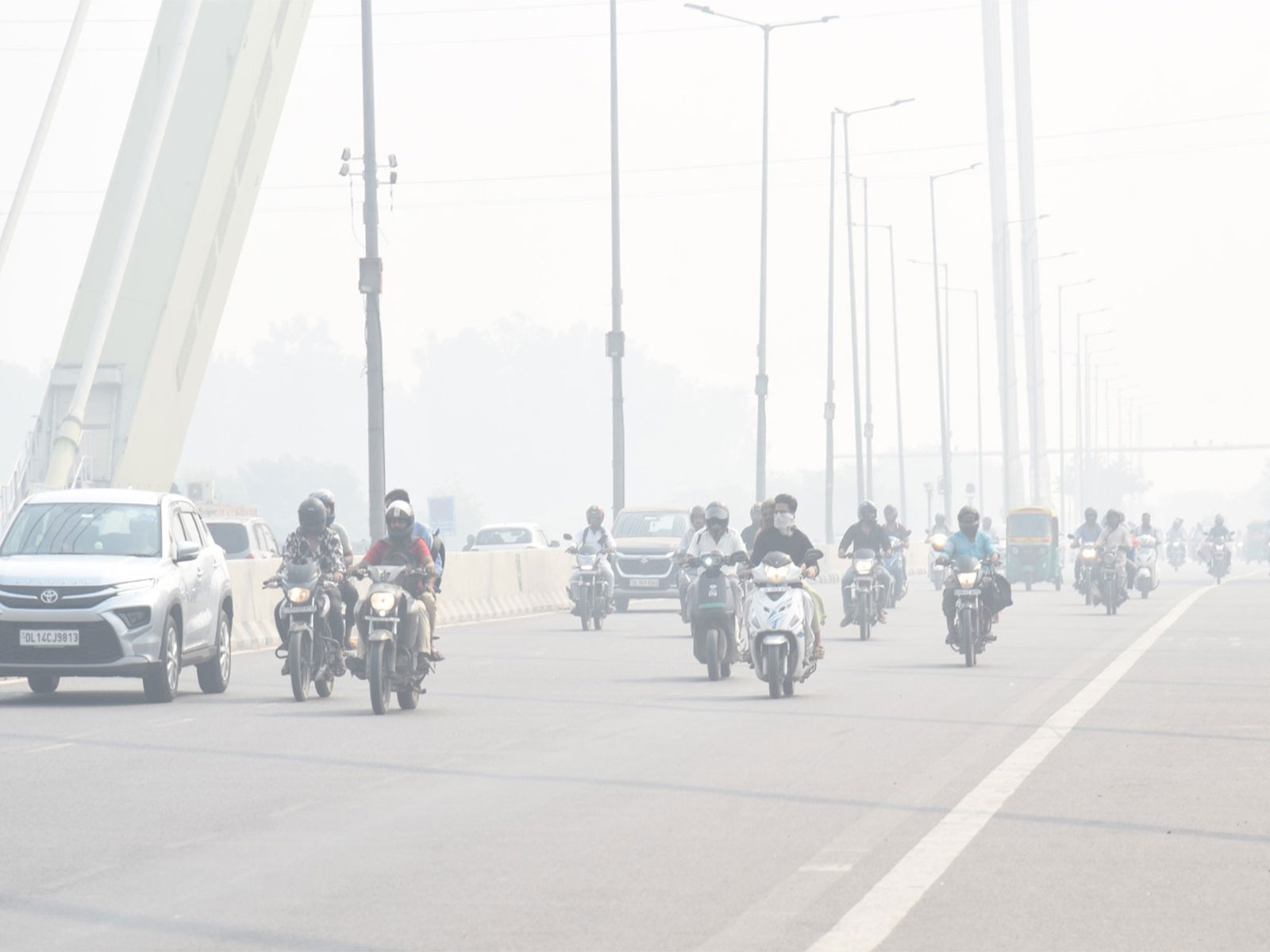 Commuters wading through a thin layer of smog at Signature Bridge in New Delhi (Photo/ANI) Commuters wading through a thin layer of smog at Signature Bridge in New Delhi (Photo/ANI)