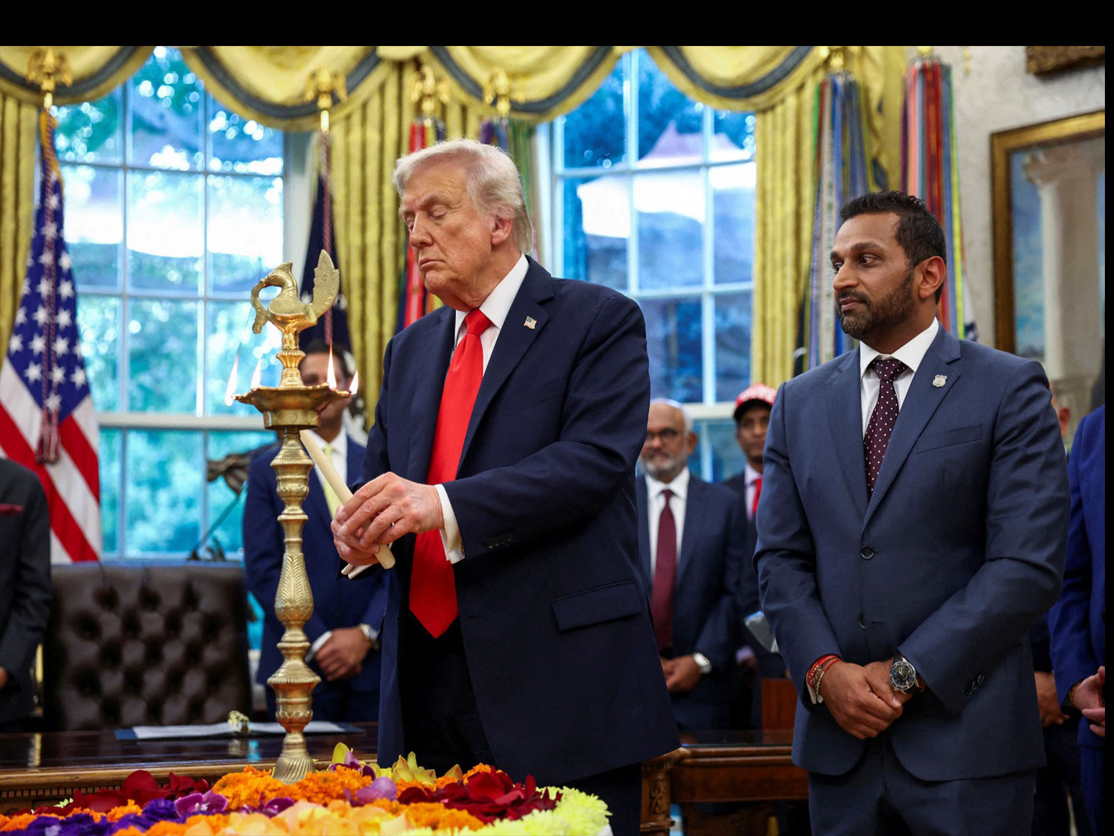 US President Donald Trump lights a candle as he participates in a Diwali celebration at the White House alongside FBI Director Kash Patel (Photo/Reuters) US President Donald Trump lights a candle as he participates in a Diwali celebration at the White House alongside FBI Director Kash Patel (Photo/Reuters)