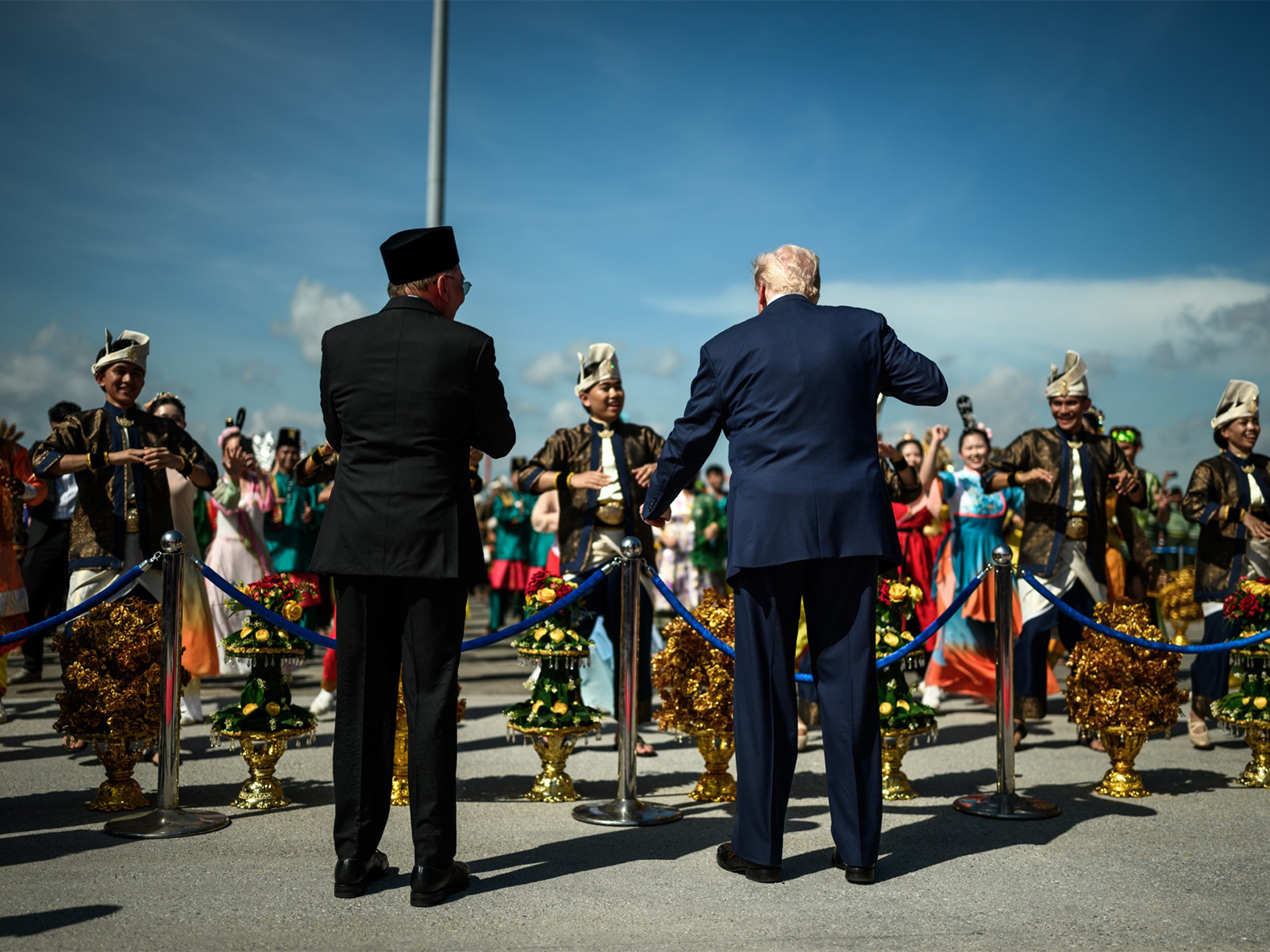 US President Donald Trump dances to drums with Malaysian PM Anwar and performers in traditional costumes at Kuala Lumpur airport. (Photo/X/@WhiteHouse) US President Donald Trump dances to drums with Malaysian PM Anwar and performers in traditional costumes at Kuala Lumpur airport. (Photo/X/@WhiteHouse)