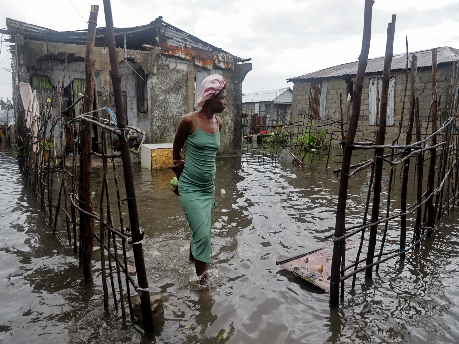 A woman stands outside her home after heavy rains from the outer bands of Hurricane Melissa flooded parts of Les Cayes, Haiti (Photo/Reuters)