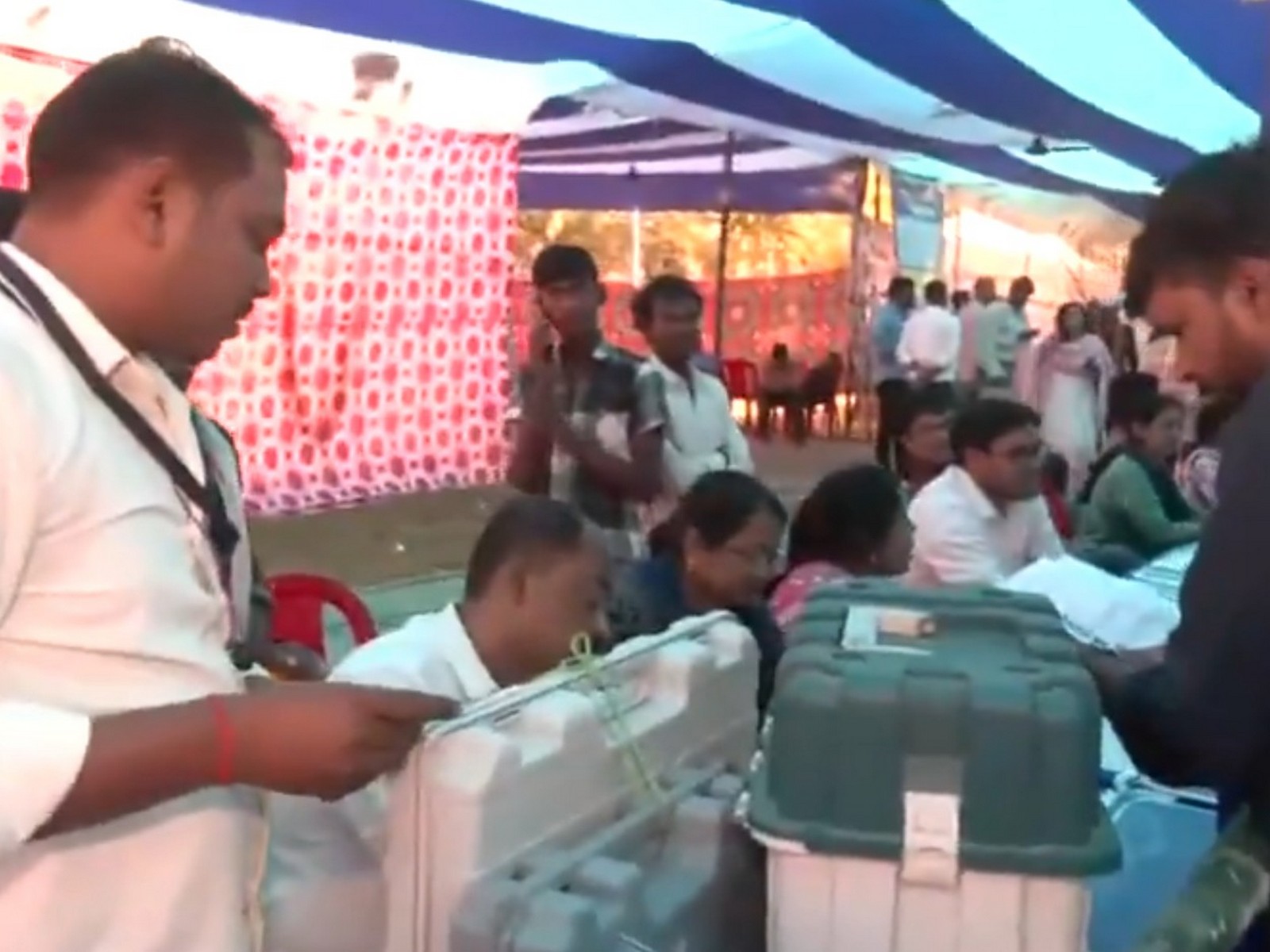 Presiding officers handing over EVMs to polling agents at a polling station in Patna (Photo/ANI)