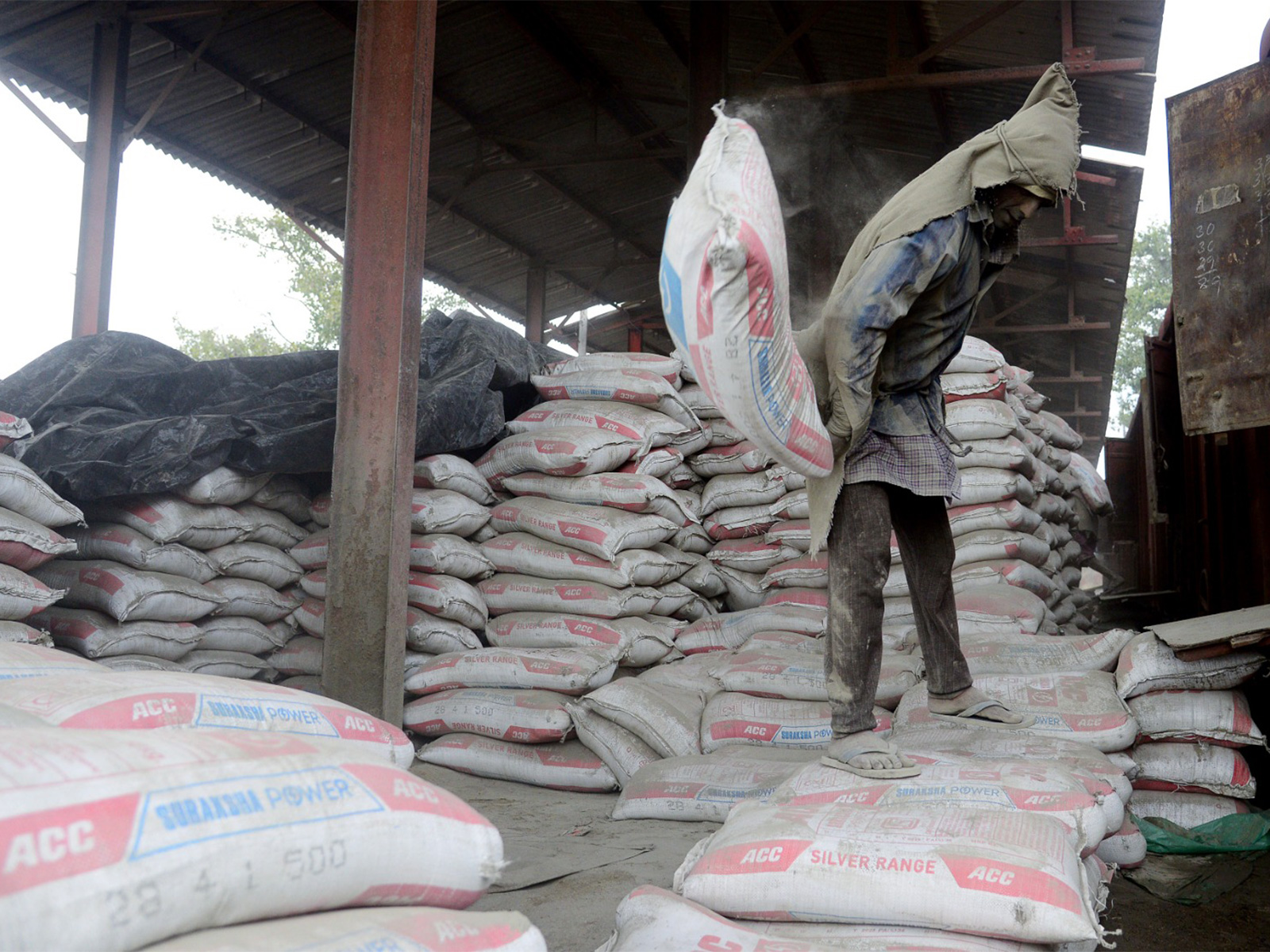 A labourer unloading cement sacks from goods train at a godown (File Photo/ANI)
