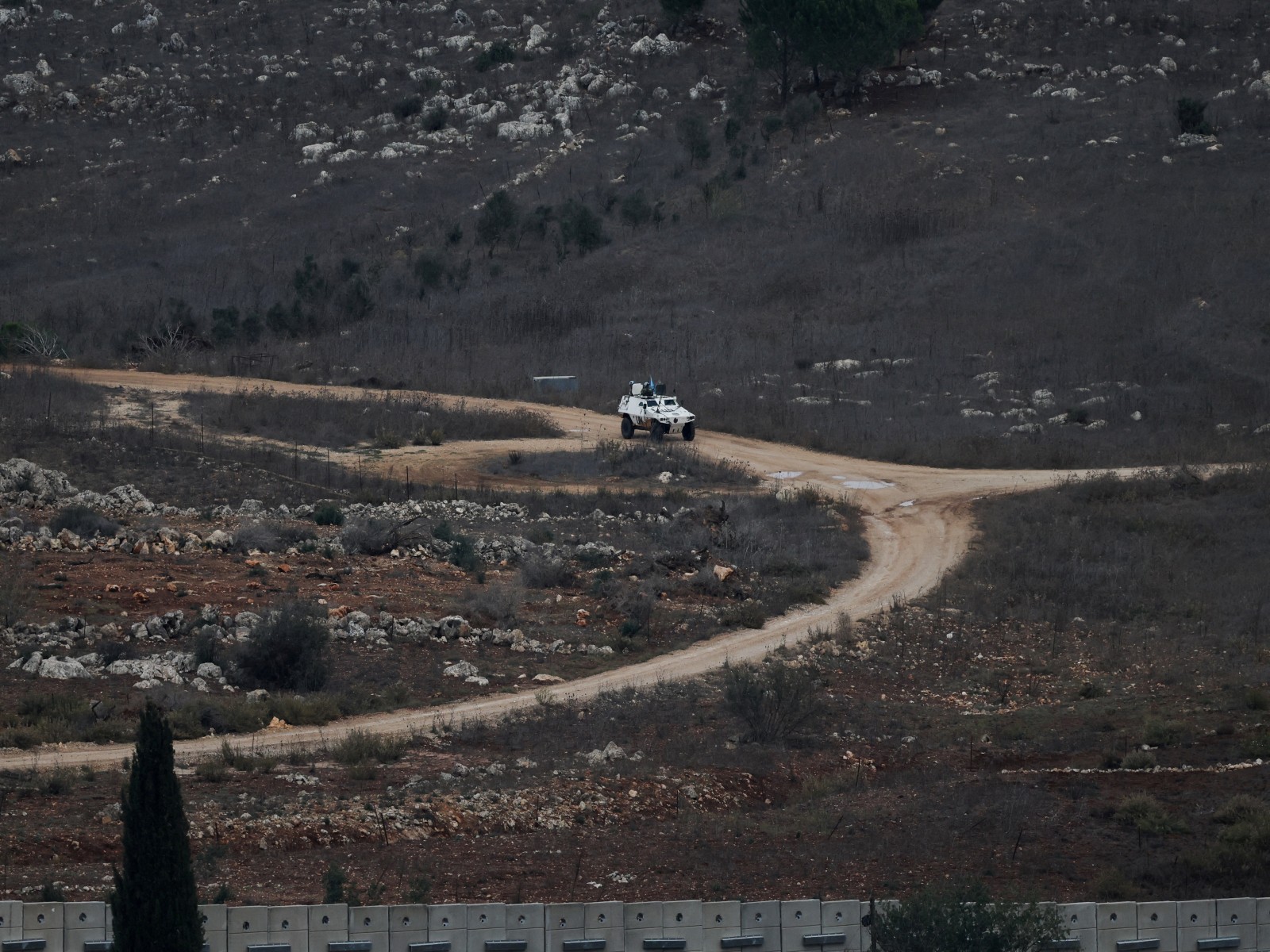 A UN vehicle drives near a concrete wall along Lebanon's southern border which, according to the Lebanese presidency, extends beyond the A UN vehicle drives near a concrete wall along Lebanon's southern border which, according to the Lebanese presidency, extends beyond the
