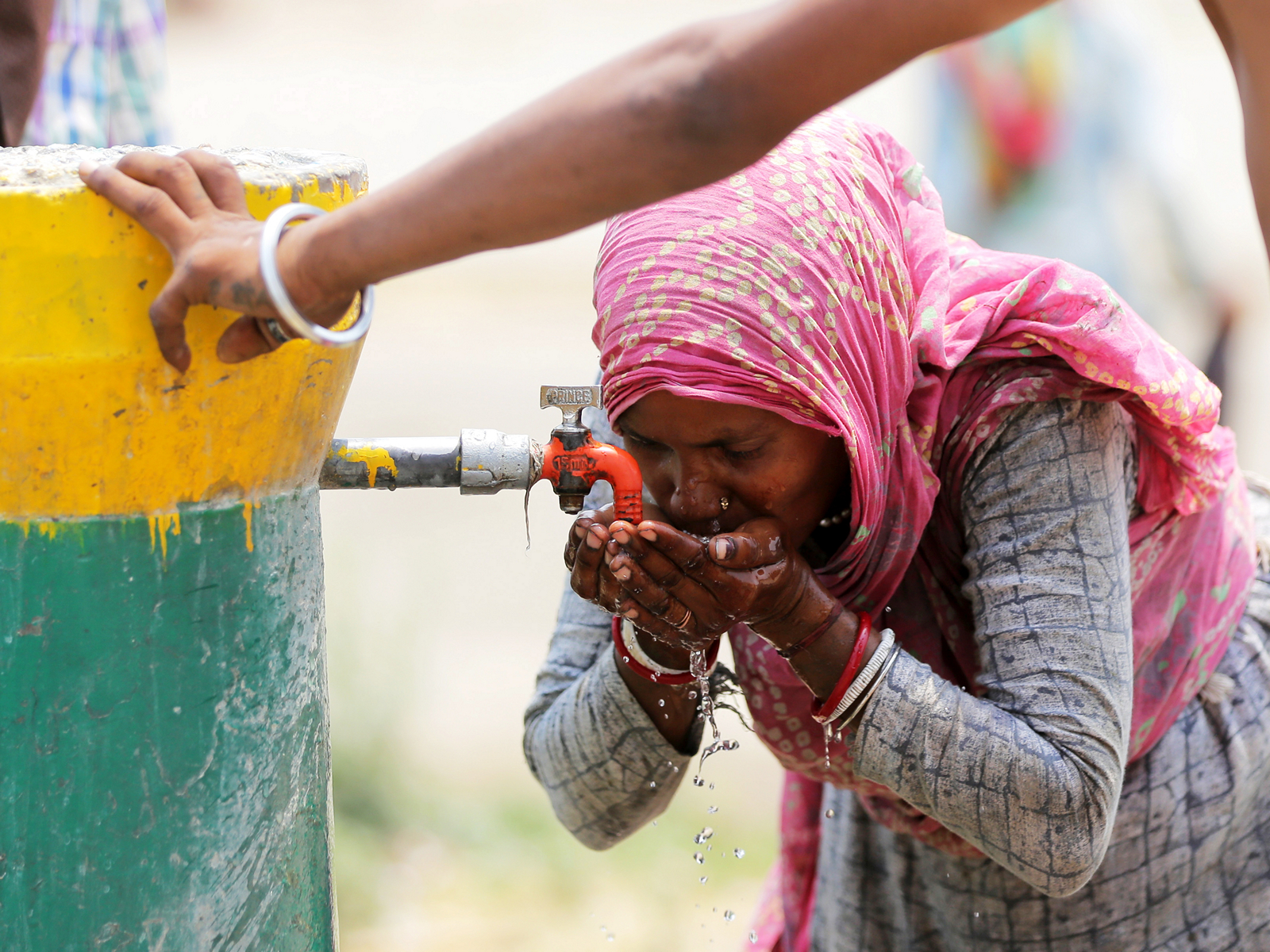 A woman drinking water from a public tap (Photo/ANI) A woman drinking water from a public tap (Photo/ANI)