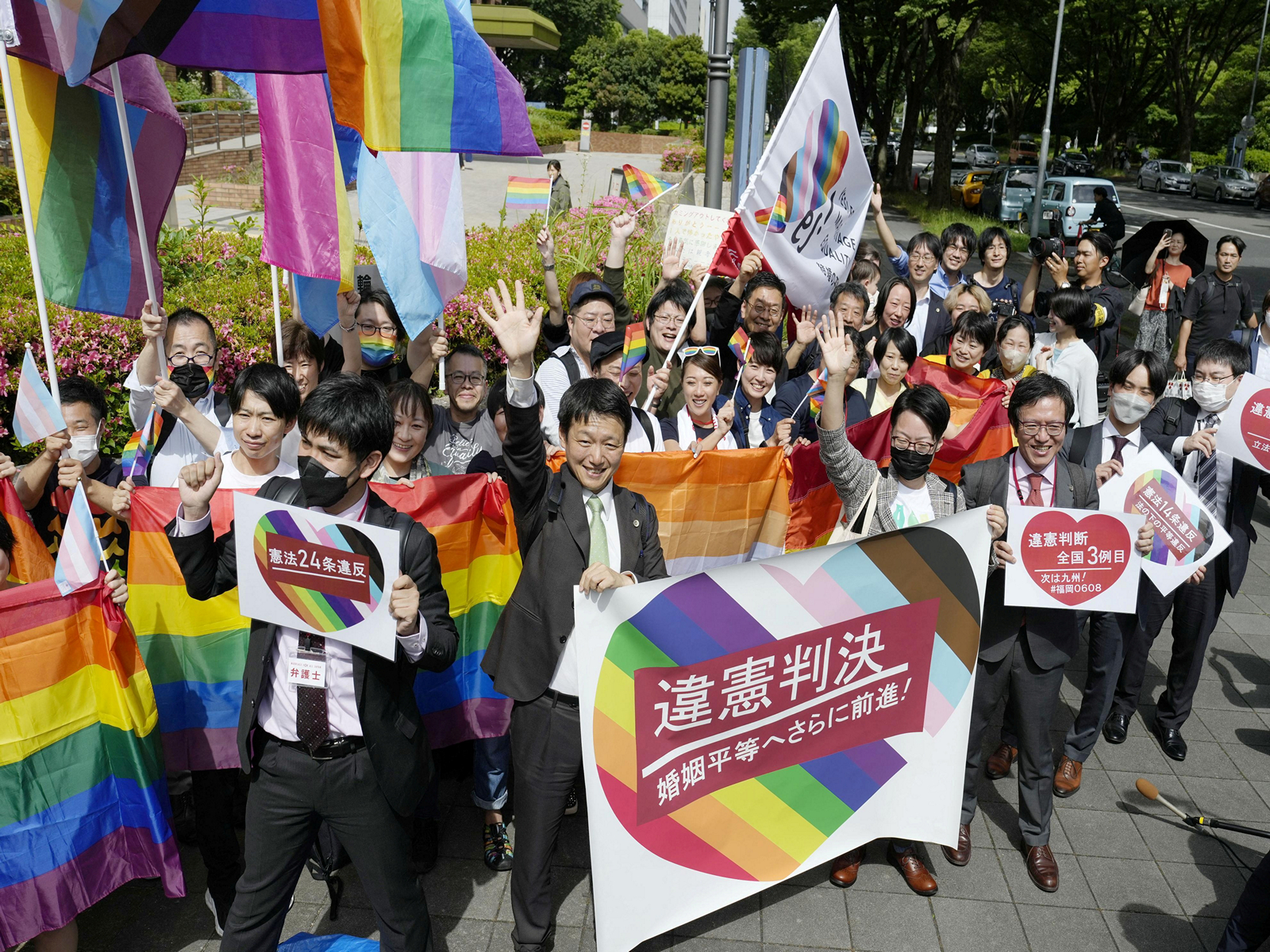 People, including the plaintiffs’ lawyers, hold banners and flags outside the Nagoya District Court after the lower court ruled that the ban on same-sex marriage was unconstitutional, in Nagoya, central Japan. (Photo/Reuters)