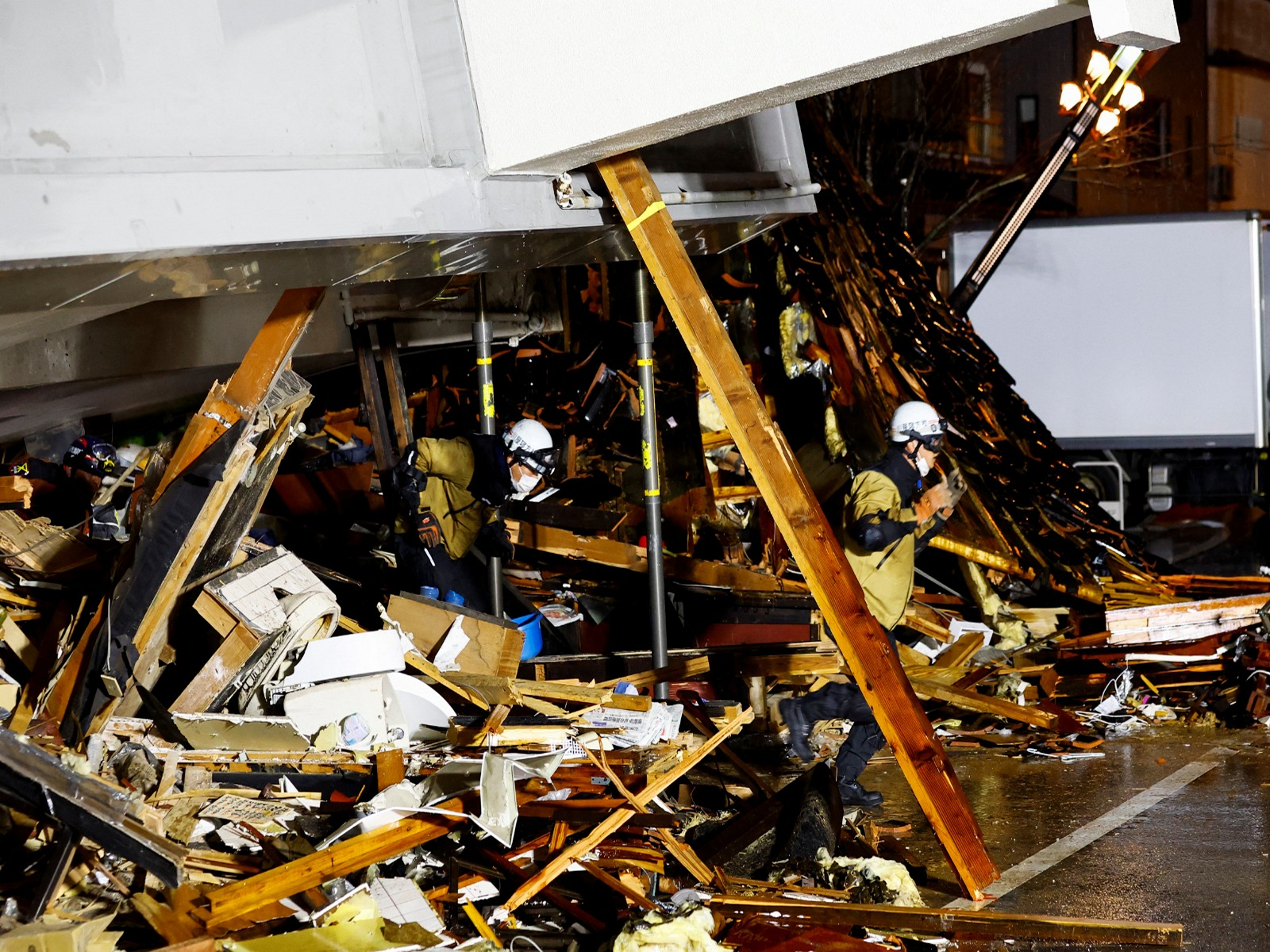 Rescue workers run out of a collapsed building after hearing an earthquake alarm, following an earthquake in Wajima, Ishikawa prefecture, Japan, January 3, 2024 (Photo/Reuters) Rescue workers run out of a collapsed building after hearing an earthquake alarm, following an earthquake in Wajima, Ishikawa prefecture, Japan, January 3, 2024 (Photo/Reuters)