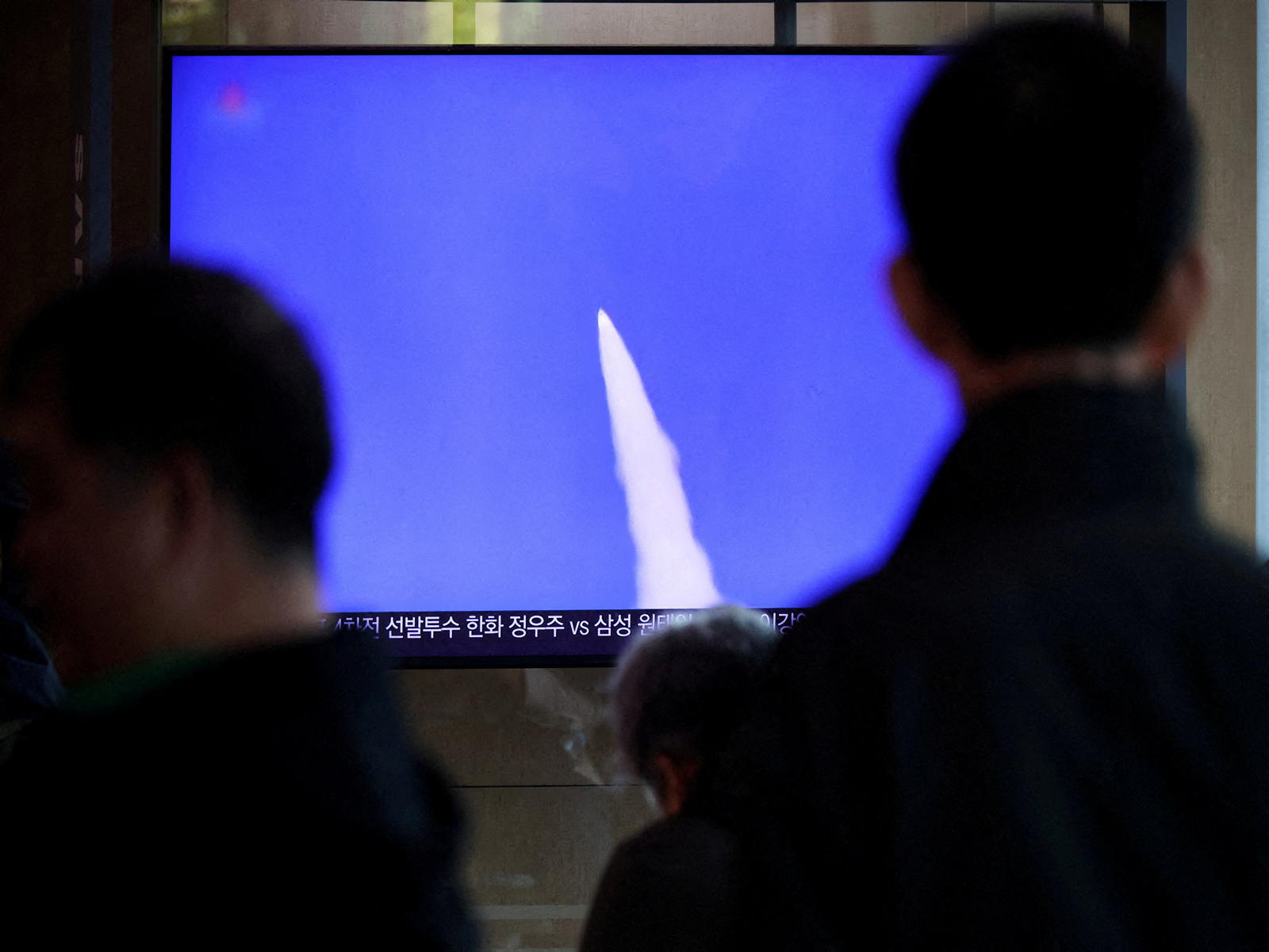 People watch a TV broadcasting a news report on North Korea firing short-range ballistic missiles (Photo/ Reuters)