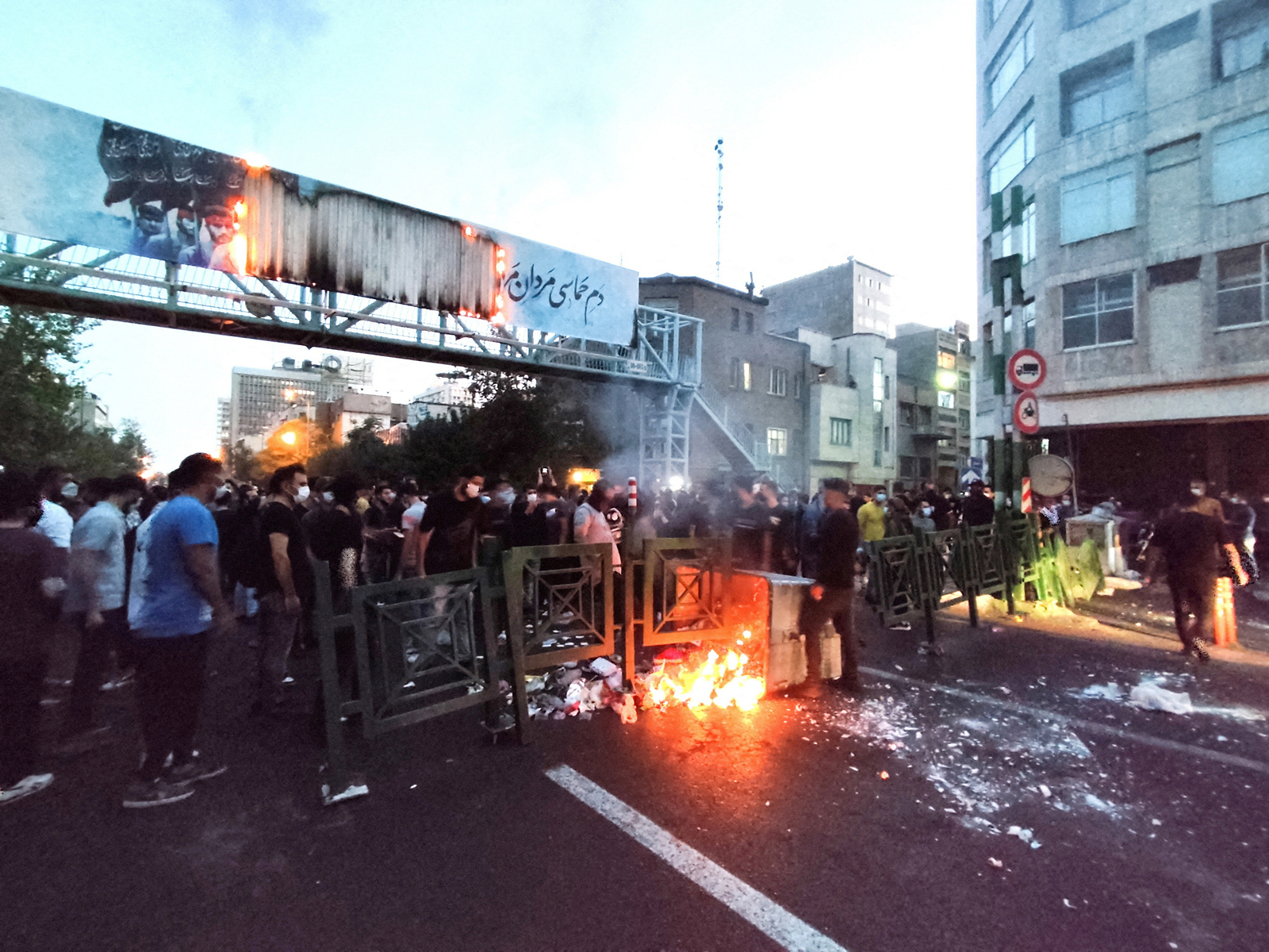 Protesters gather on a street in Iran as barricades burn during ongoing anti-government demonstrations, with security personnel deployed to control the situation. (Photo/Reuters)