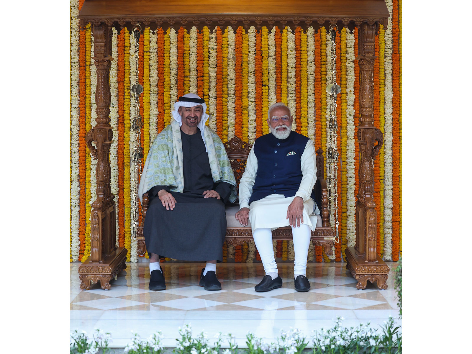 Prime Minister Narendra Modi and UAE President Sheikh Mohamed bin Zayed Al Nahyan sit on the Royal carved wooden Jhula gifted as part of traditional Indian presents during the UAE leader’s official visit, at Lok Kalyan Marg in New Delhi (Photo/PMO)