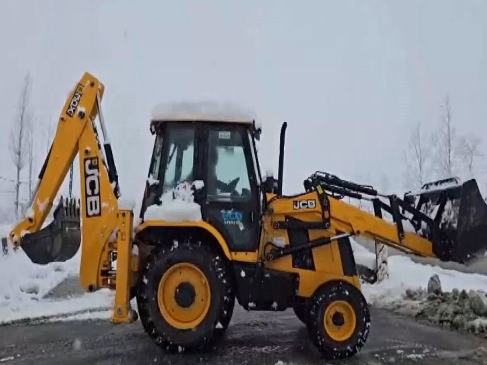 Clearance work is underway as heavy snowfall leads to a traffic halt at the Jammu-Srinagar highway in the Qazigund area. (Photo/ANI)
