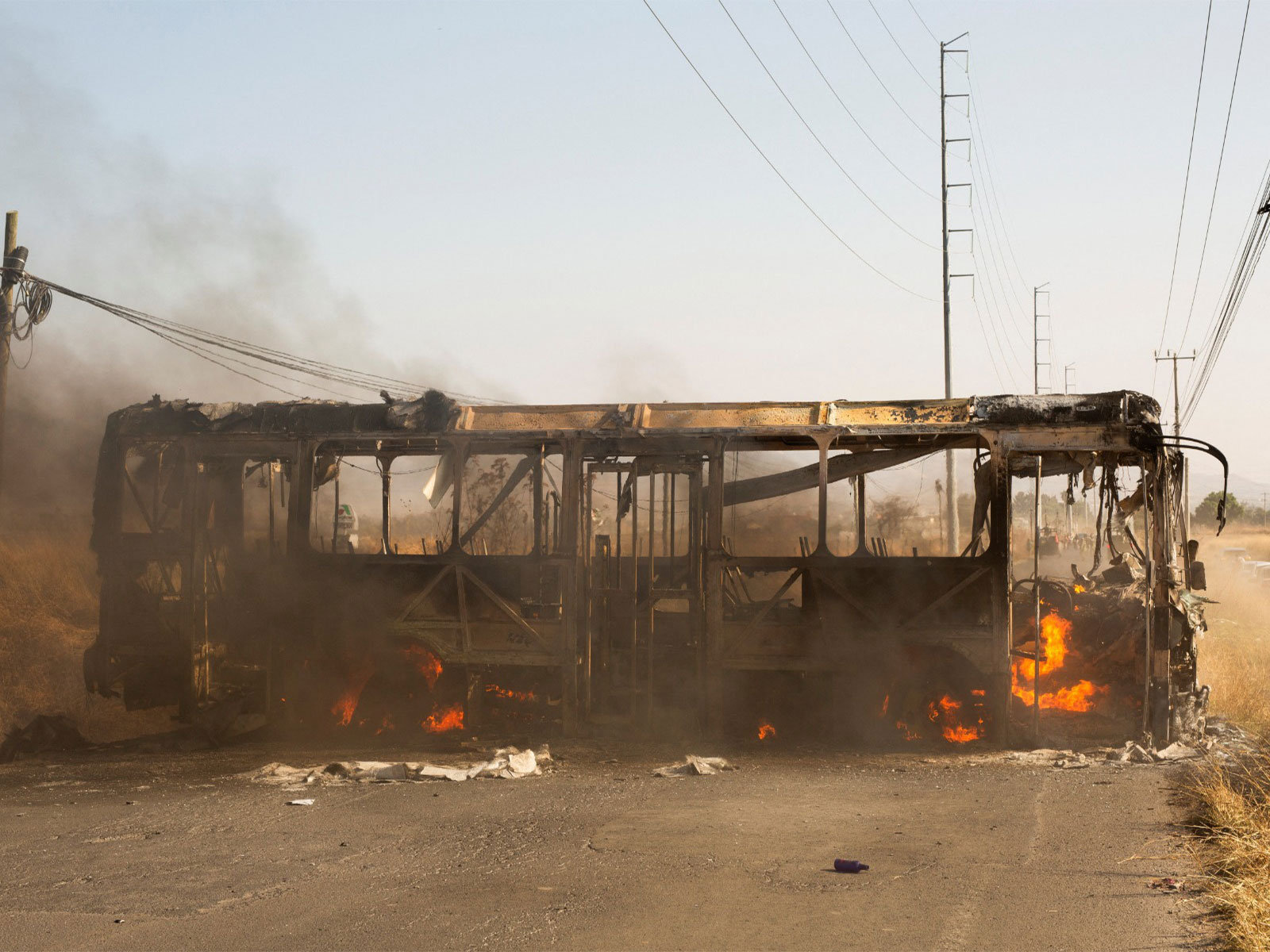 A bus used as a roadblock by organized crime burns following the killingv of A bus used as a roadblock by organized crime burns following the killingv of