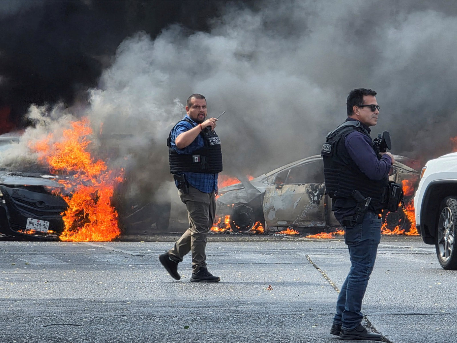 Police officers secure the area where vehicles were set on fire following killing of El Mencho (Photo/Reuters)