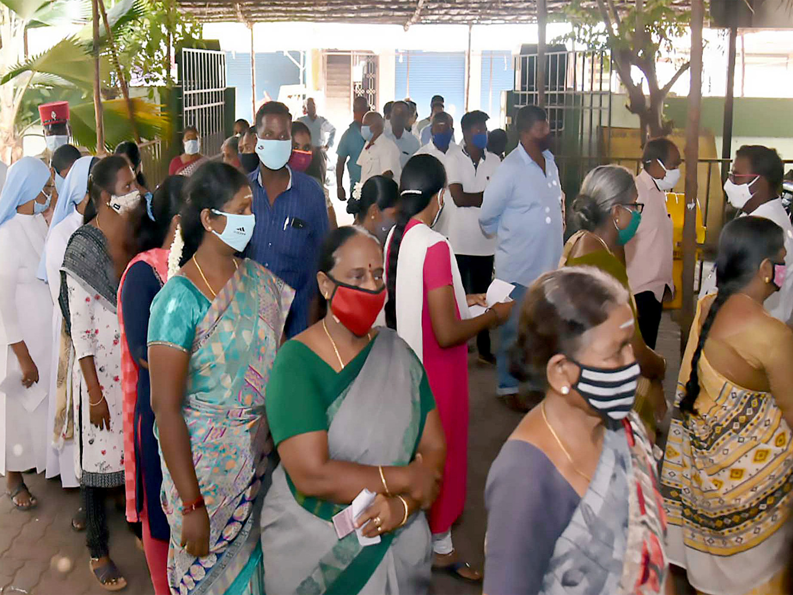Voters standing in queue to cast their votes at a polling booth. (Photo/ANI)