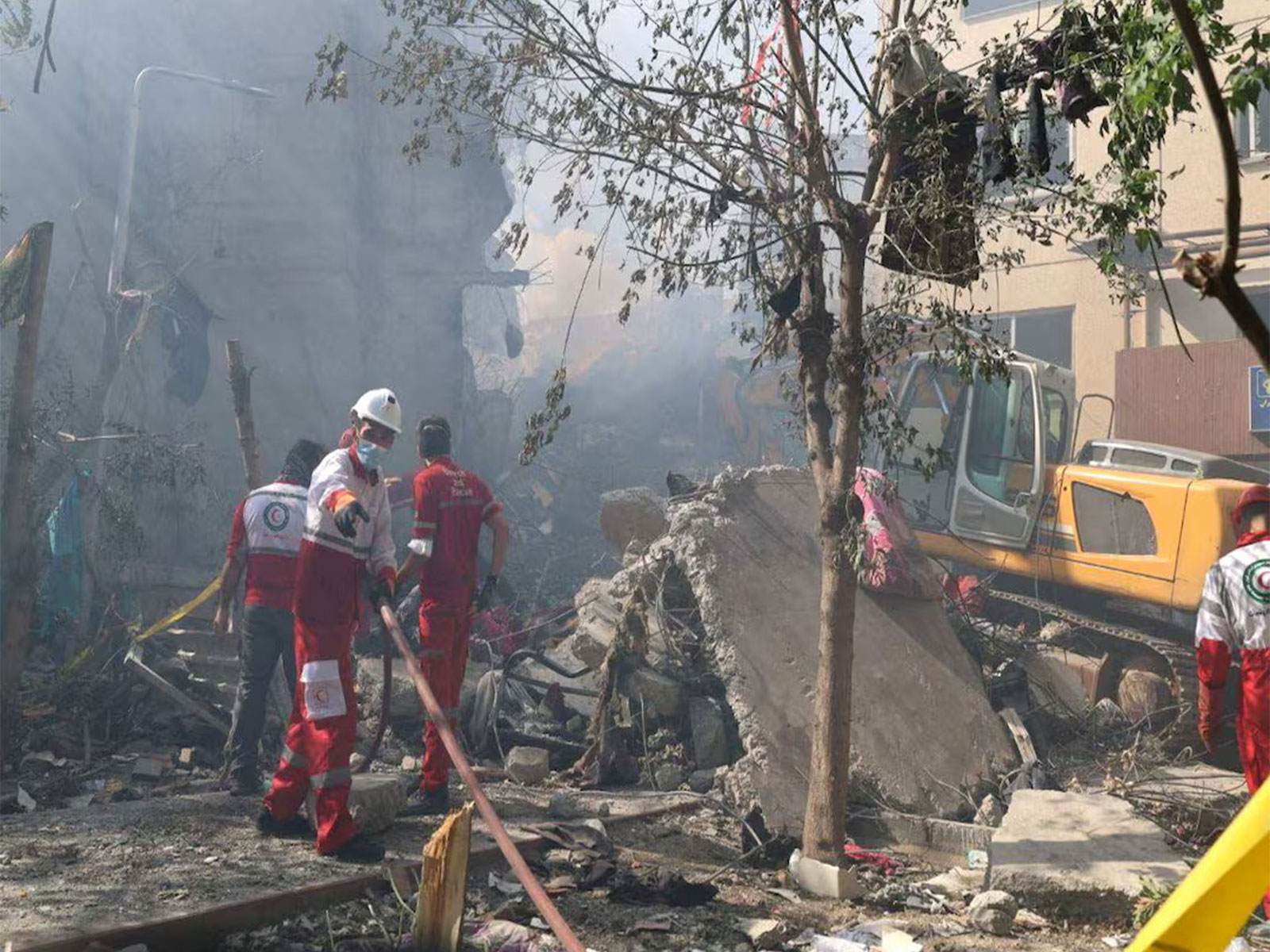 Rescuers search through debris at a damaged building following Israeli strikes in Tehran, Iran. (Photo/Reuters)