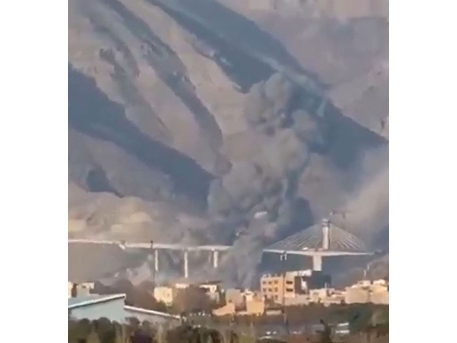 Smoke rises near Karaj’s B1 bridge following reported strikes that caused civilian casualties and damage in the surrounding area. (Image Source: Iranian state media)