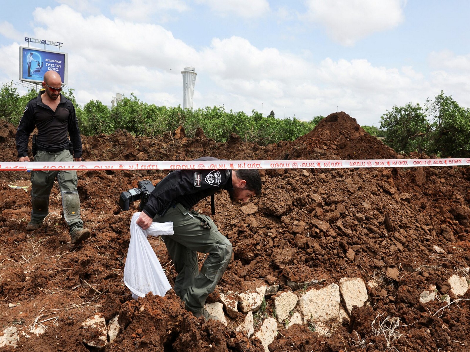 Following a missile launch from Yemen, Israeli police officers examine an impact crater near Tel Aviv's Ben Gurion Airport. (Photo/Reuters) Following a missile launch from Yemen, Israeli police officers examine an impact crater near Tel Aviv's Ben Gurion Airport. (Photo/Reuters)