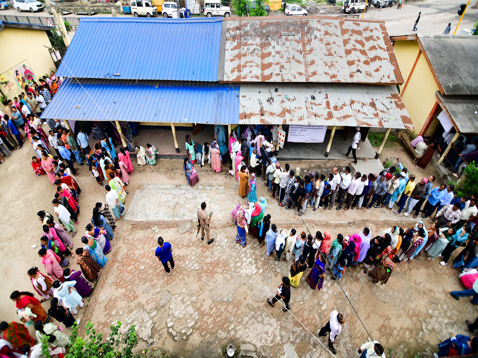 Voters queue up at a polling booth in Guwahati (Photo/ANI)