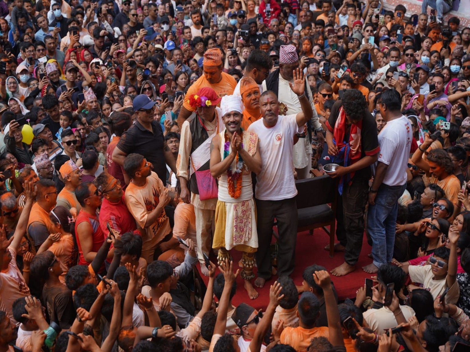 Devotee Sujan Bagh Shrestha stands on a platform amid a large crowd after performing the tongue-piercing ritual during Jibro Chedne Jatra in Bode, Bhaktapur. (Photo/ANI)