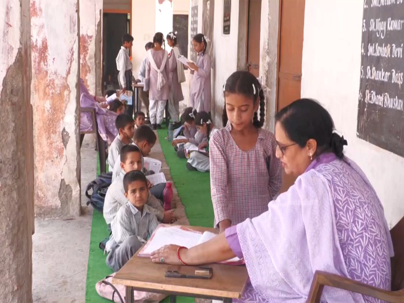 Students studying outside the government middle school due to cracked infrastructure in Udhampur (Photo/ANI) Students studying outside the government middle school due to cracked infrastructure in Udhampur (Photo/ANI)
