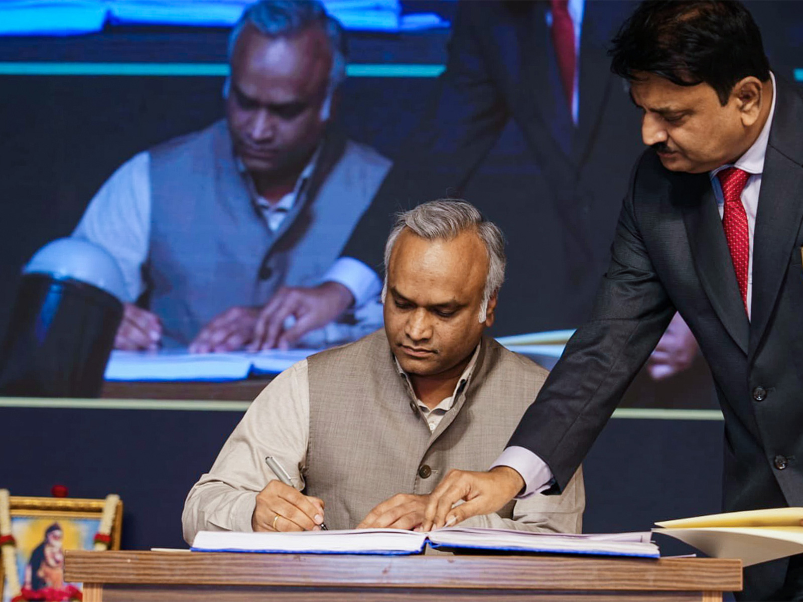 Congress leader Priyank Kharge signs documents after he takes oath (Photo/ANI)