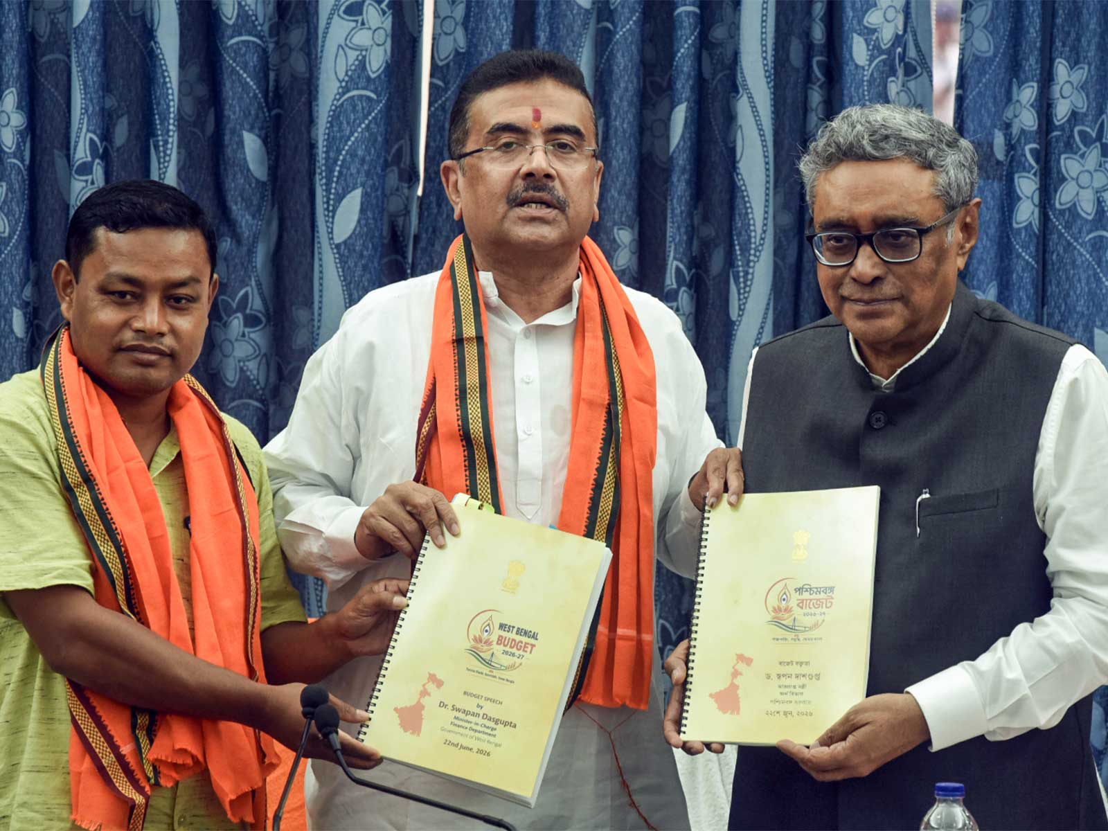 West Bengal CM Suvendu Adhikari, accompanied by State Finance Minister Swapan Dasgupta (right) and BJP MLA Anandamay Barman Hold Budget 2026 Book After Assembly Meeting (Photo/ANI) West Bengal CM Suvendu Adhikari, accompanied by State Finance Minister Swapan Dasgupta (right) and BJP MLA Anandamay Barman Hold Budget 2026 Book After Assembly Meeting (Photo/ANI)
