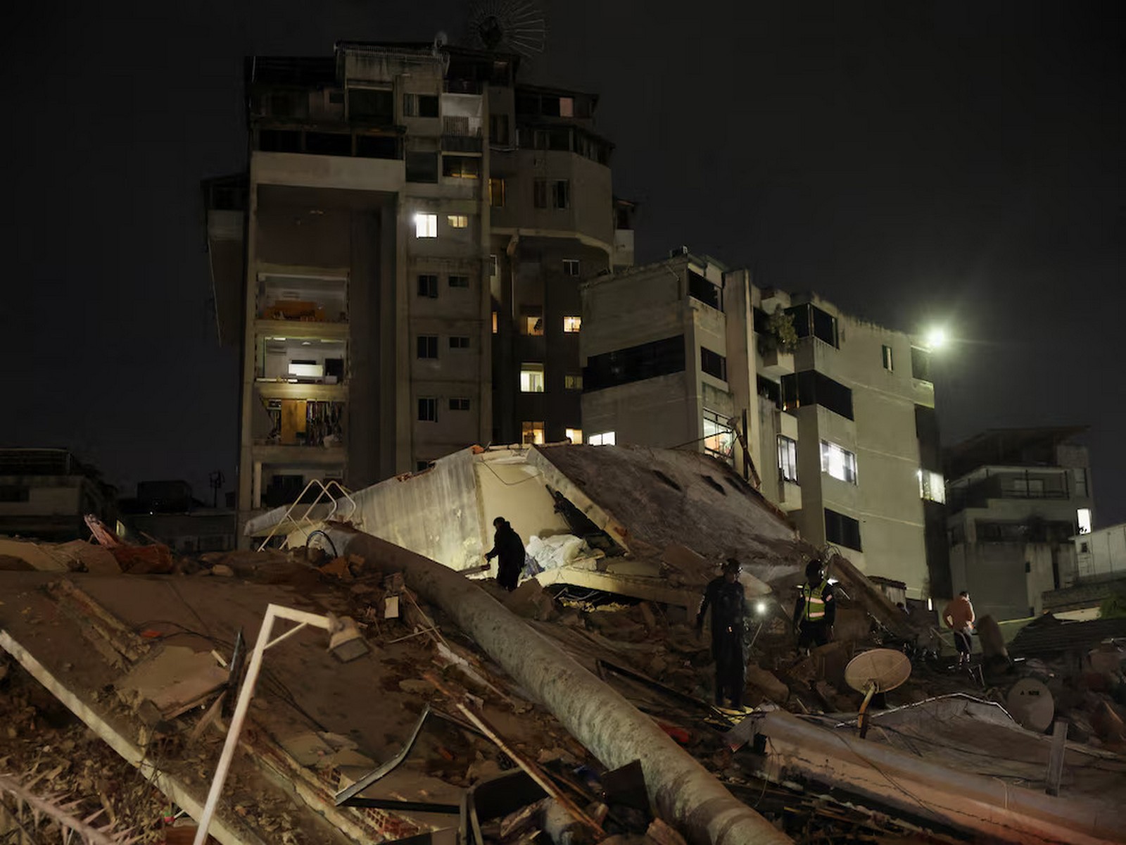 Emergency personnel conduct rescue operations at the site of a building collapse following a powerful earthquake in Caracas, Venezuela. (Photo/Reuters)