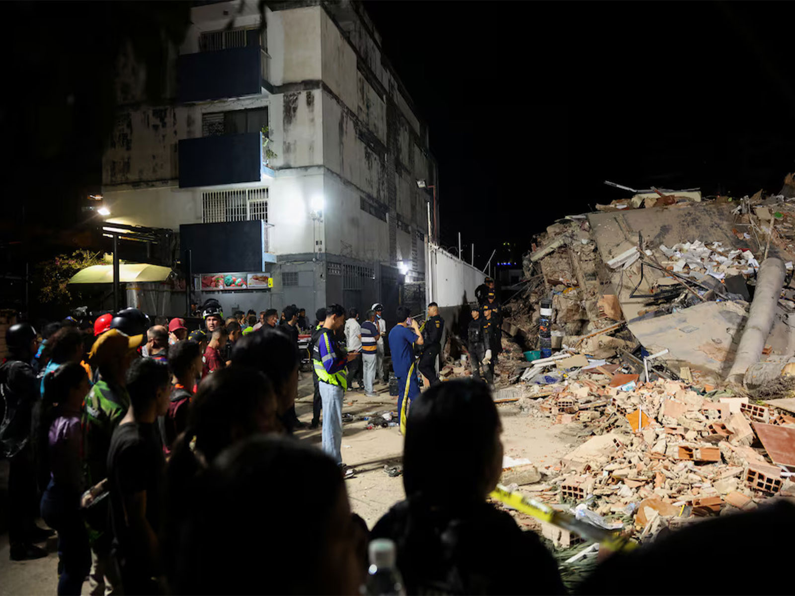 People gather near a collapsed building as emergency personnel carry out rescue operations following the devastating earthquakes in Caracas, Venezuela. (Photo/Reuters)
