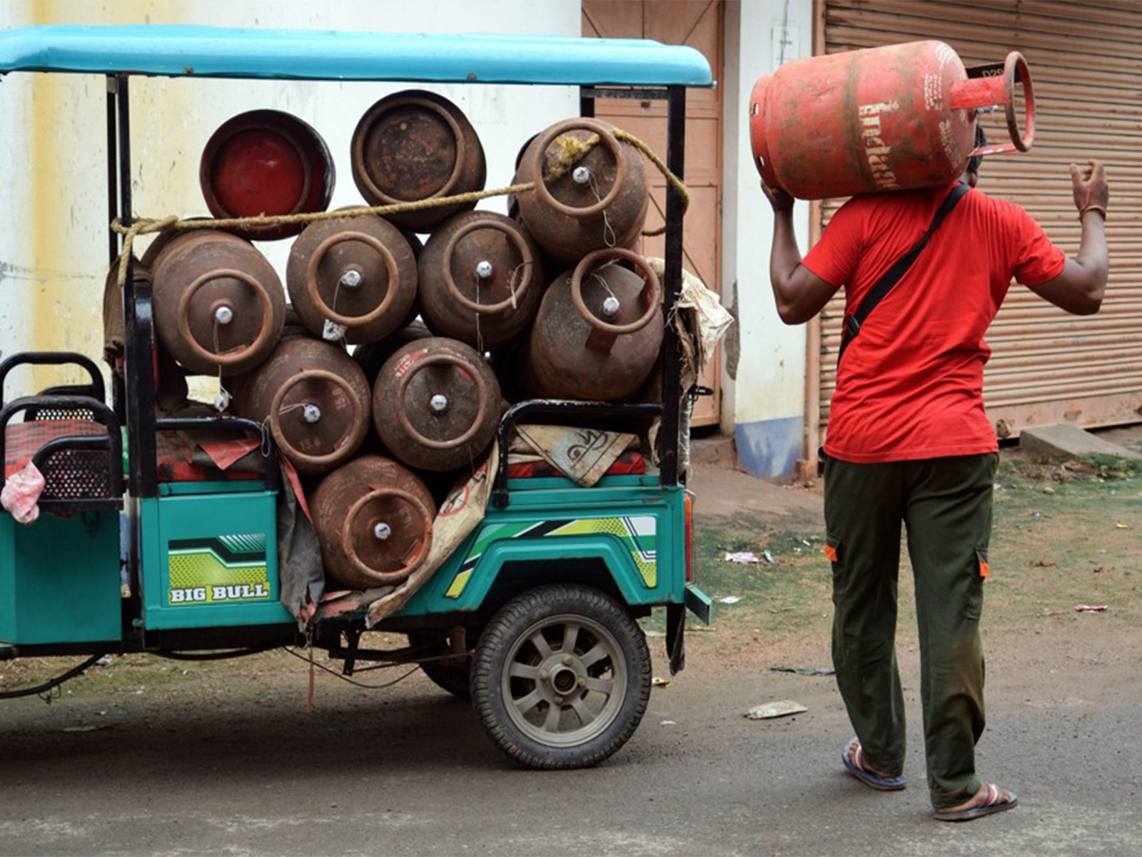 A worker carries LPG gas cylinders for delivery (Representational Image) (File Photo/ANI)