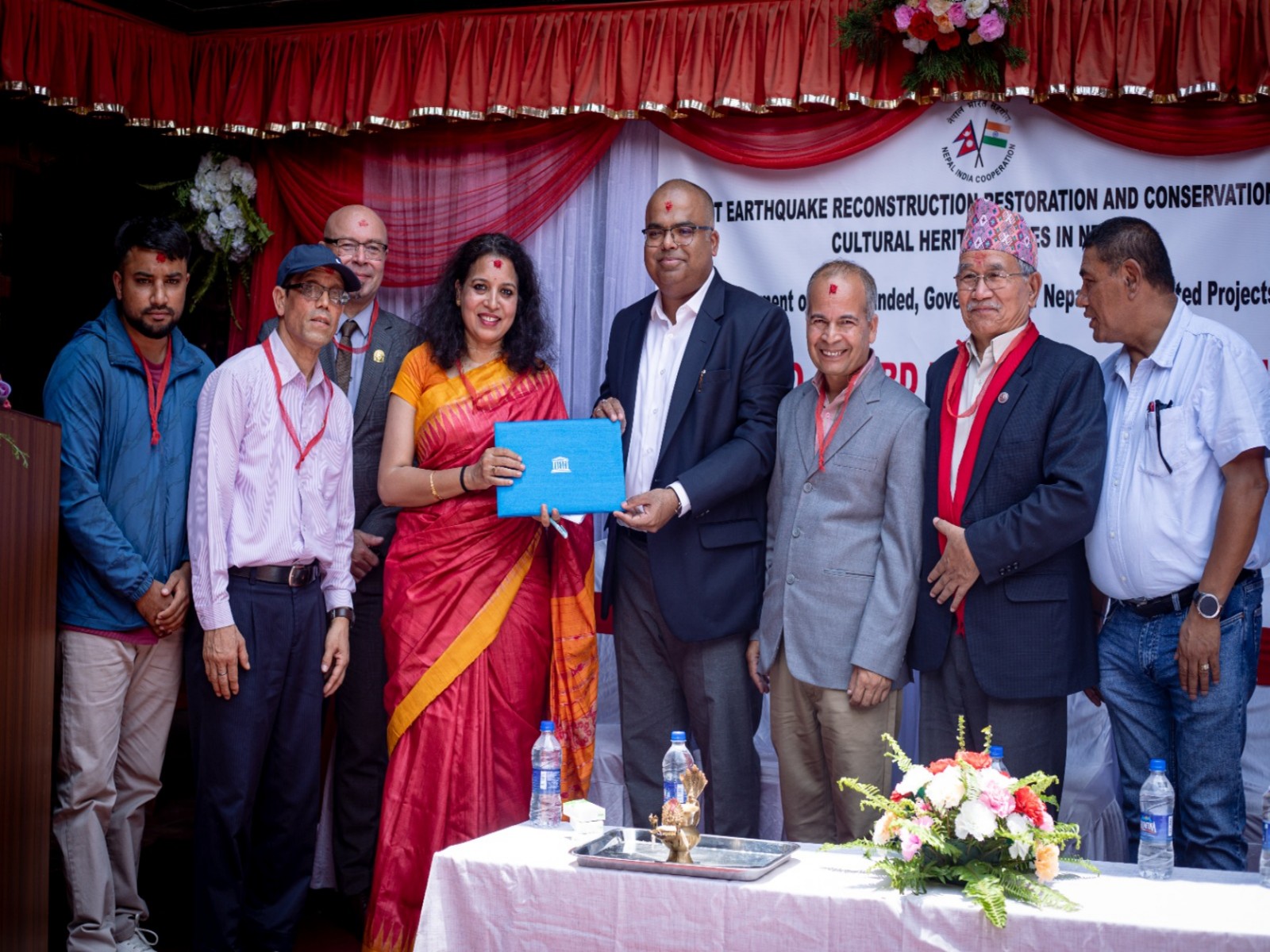 Officials present the UNESCO Asia-Pacific Award of Merit certificate to the Jestha Varna Mahavihar User Committee during a ceremony in Lalitpur, Nepal. (Image Source: Indian Embassy in Kathmandu) Officials present the UNESCO Asia-Pacific Award of Merit certificate to the Jestha Varna Mahavihar User Committee during a ceremony in Lalitpur, Nepal. (Image Source: Indian Embassy in Kathmandu)