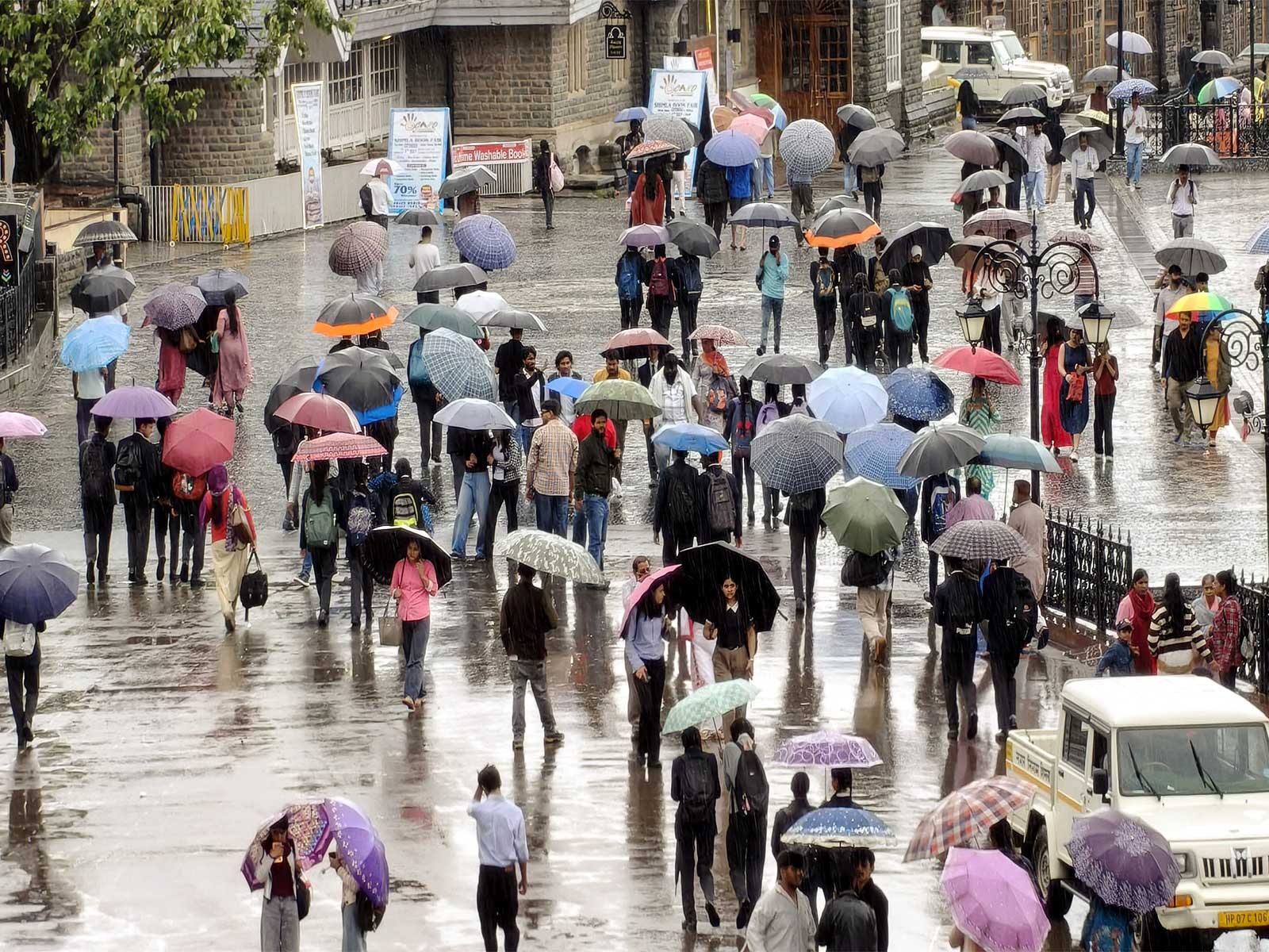 People cover themselves with umbrellas as they walk amid rainfall (Photo/ANI) People cover themselves with umbrellas as they walk amid rainfall (Photo/ANI)
