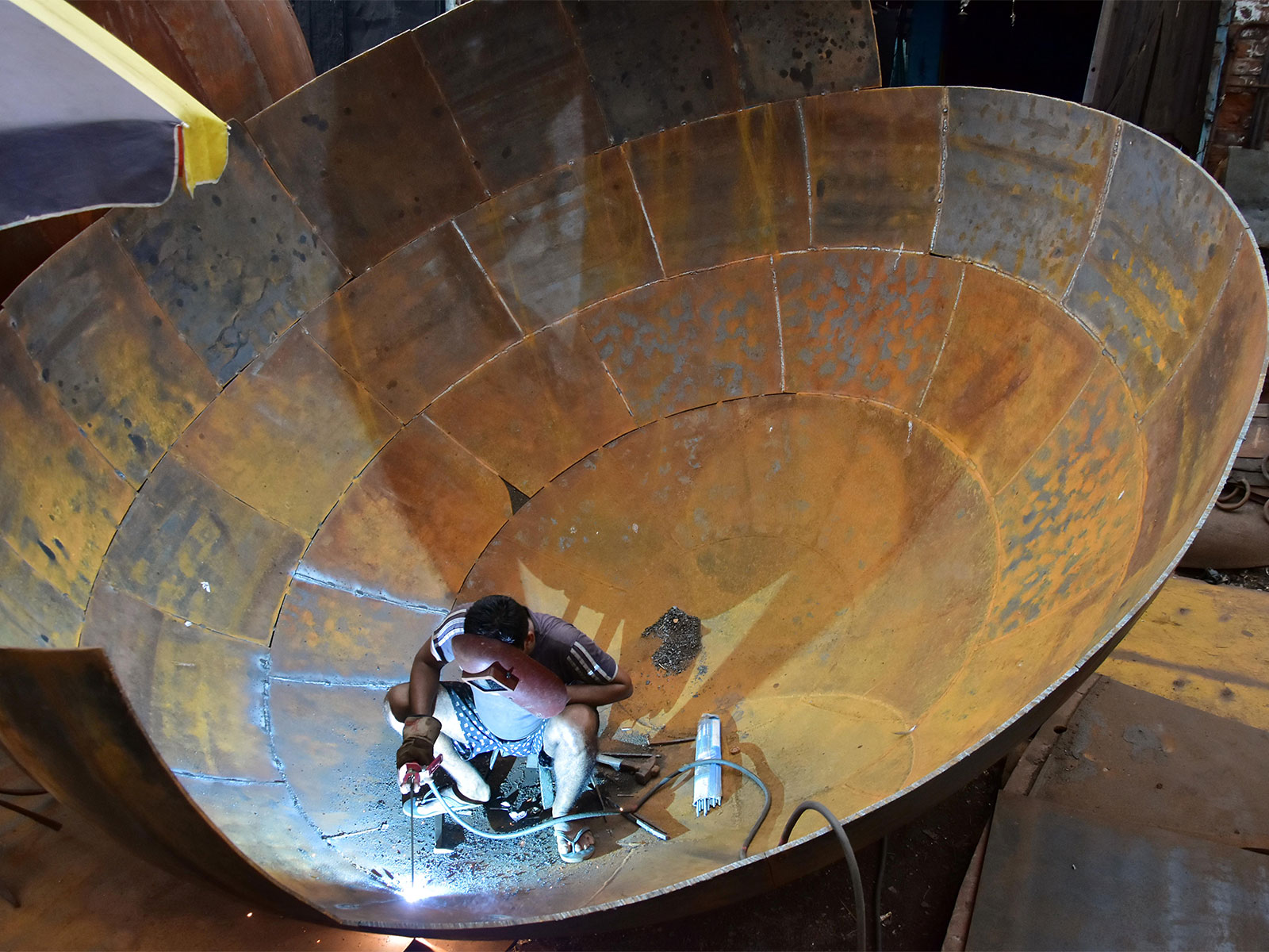 A labourer welding a giant iron pot at an iron factory in Kolkata  (File Photo/ANI)
