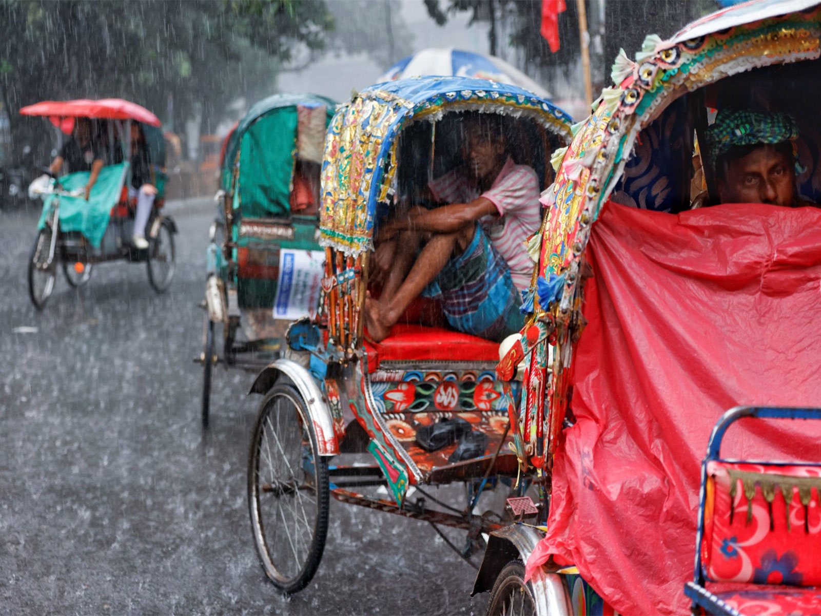 Rickshaw drivers sit inside of their rickshaws to take cover during torrential rain in Dhaka, Bangladesh (Photo/Reuters) Rickshaw drivers sit inside of their rickshaws to take cover during torrential rain in Dhaka, Bangladesh (Photo/Reuters)