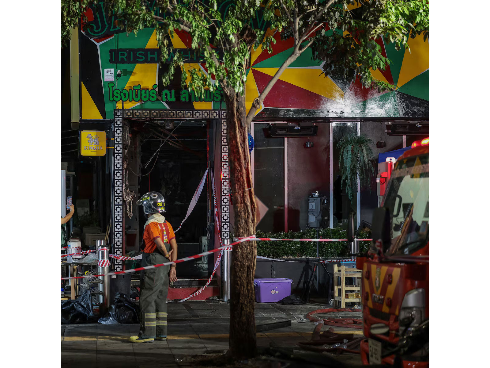 Firefighters and emergency personnel stand outside the fire-ravaged Na Ladprao eatery in Bangkok's Chatuchak district after a deadly blaze killed at least 27 people and injured dozens in the early hours of Monday. (Photo/Reuters) Firefighters and emergency personnel stand outside the fire-ravaged Na Ladprao eatery in Bangkok's Chatuchak district after a deadly blaze killed at least 27 people and injured dozens in the early hours of Monday. (Photo/Reuters)