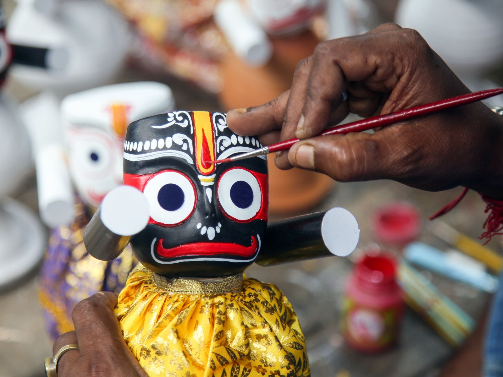 An artisan painting the facial features of a Lord Jagannath idol (Photo/ANI)