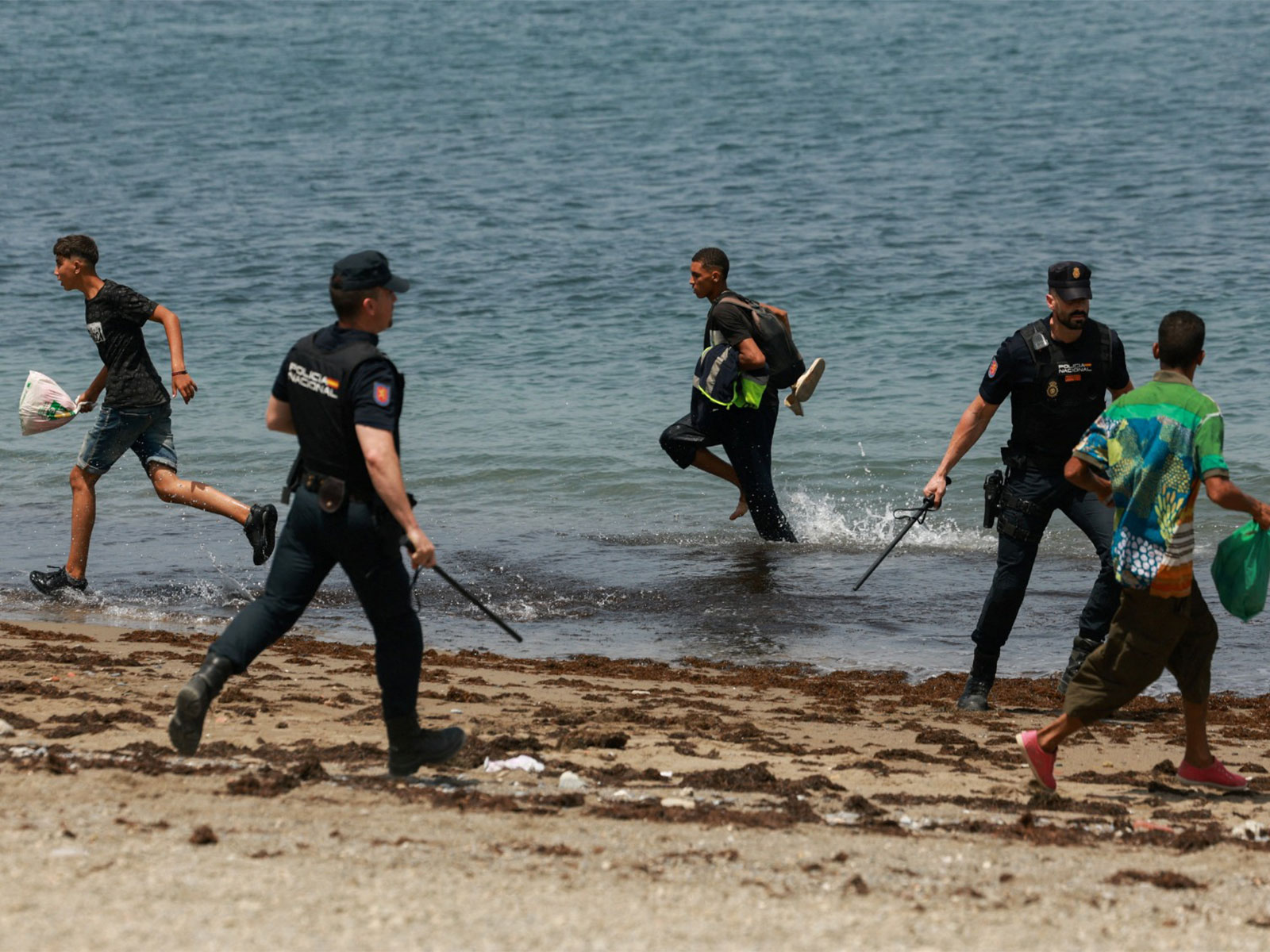 Migrants try to make their way past Spanish police officers, following recent mass crossings of migrants on foot and by sea from Morocco into Spanish territory, in Ceuta, Spain (Photo/Reuters) Migrants try to make their way past Spanish police officers, following recent mass crossings of migrants on foot and by sea from Morocco into Spanish territory, in Ceuta, Spain (Photo/Reuters)