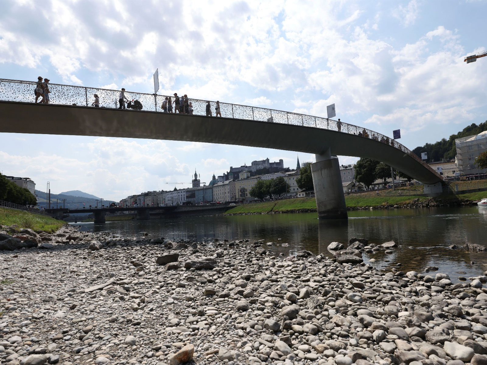 People walk on a bridge over river Salzach during a period of low water level in Salzburg, Austria (Photo/Reuters)