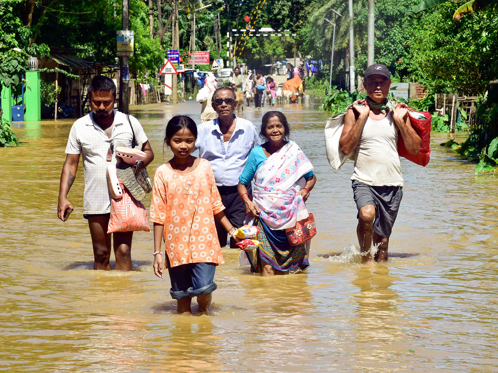 People moving to safer places carrying their belongings in a flood-affected area (File Photo/ANI) People moving to safer places carrying their belongings in a flood-affected area (File Photo/ANI)
