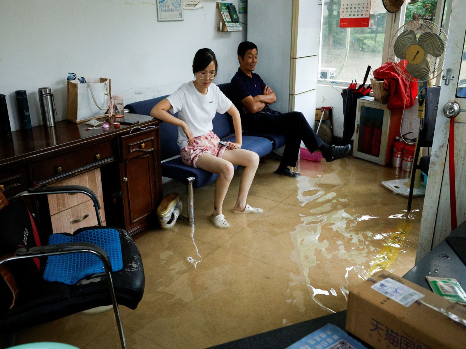 People in a flooded room after Typhoon Dolphin brought heavy rain to Shanghai in China, August 10, 2026. (Photo/Reuters)
