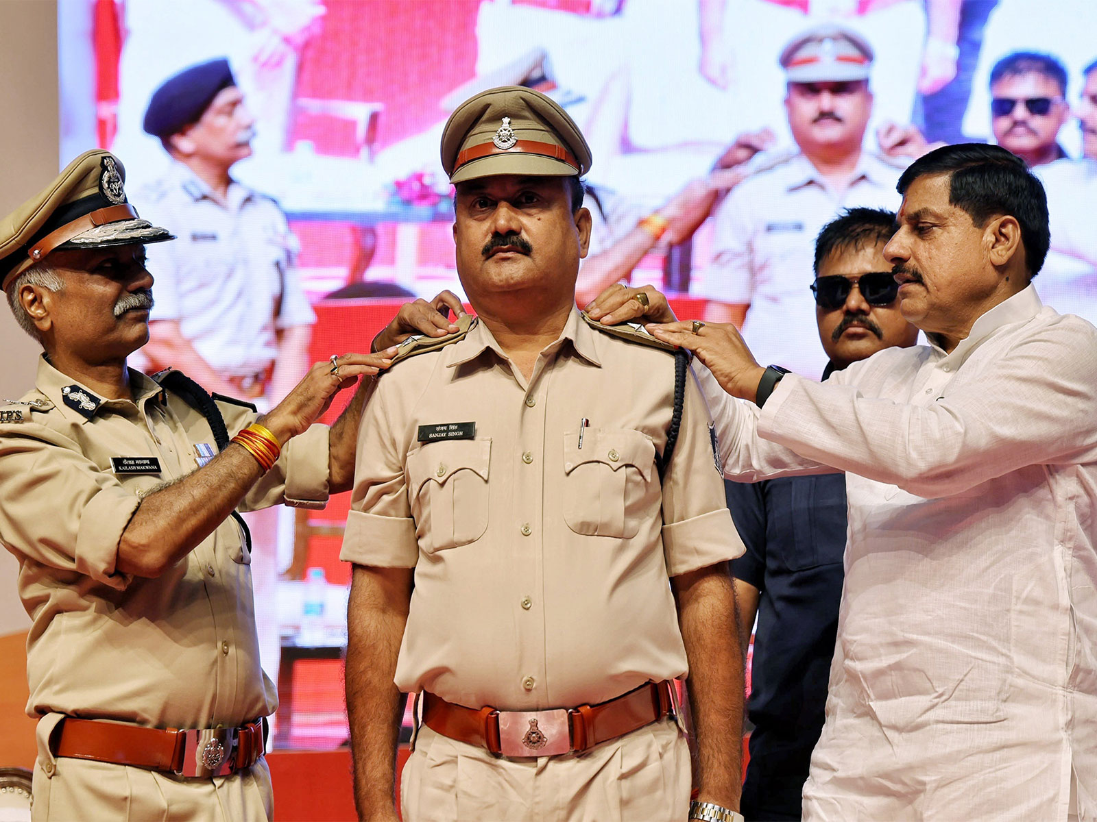 MP CM Mohan Yadav applying badge to a promoted police personnel (Photo/X @DrMohanYadav51) MP CM Mohan Yadav applying badge to a promoted police personnel (Photo/X @DrMohanYadav51)