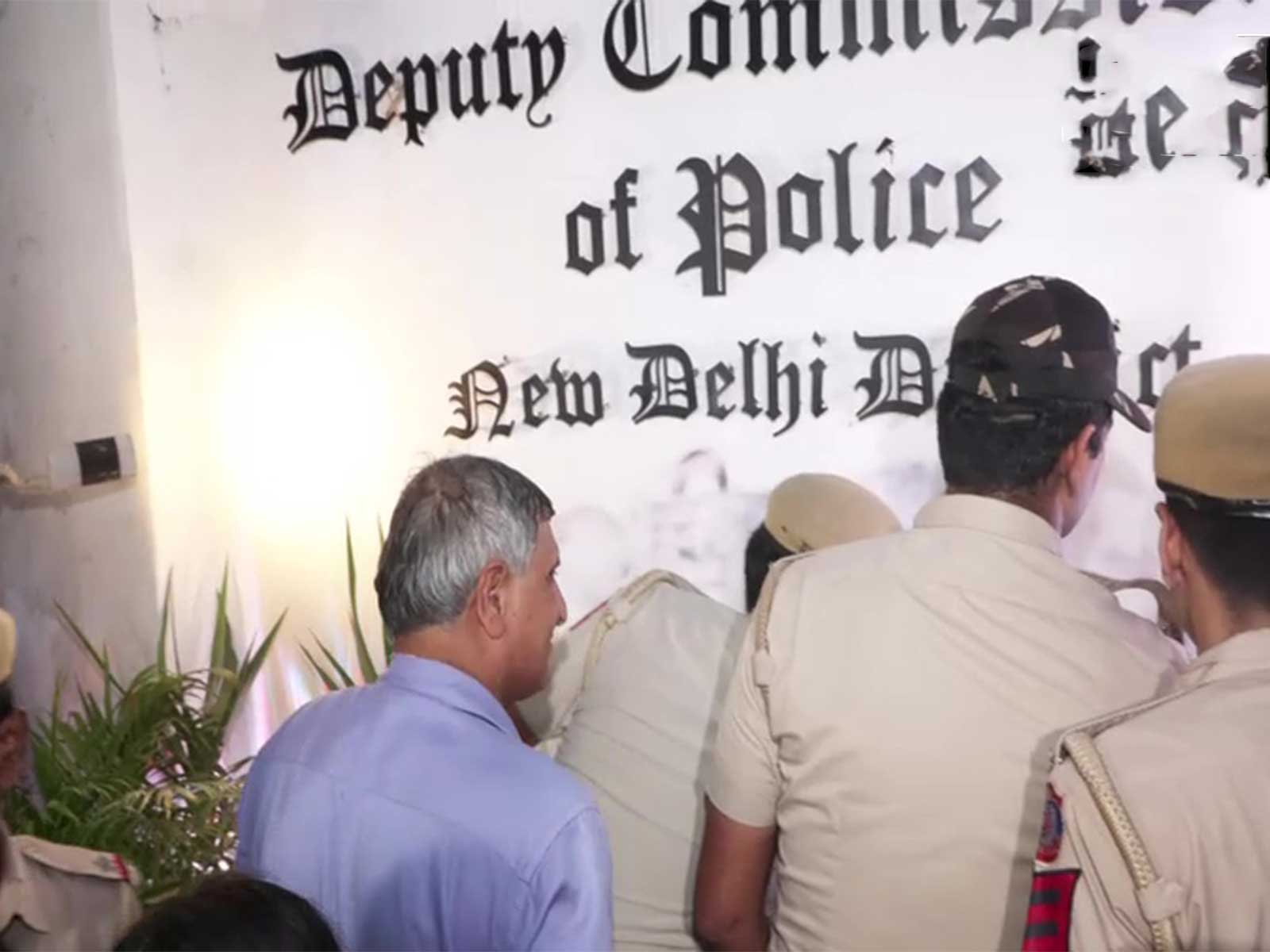 Delhi police removing the graffiti put on Parliament street police station on August 21 (Photo/ANI)