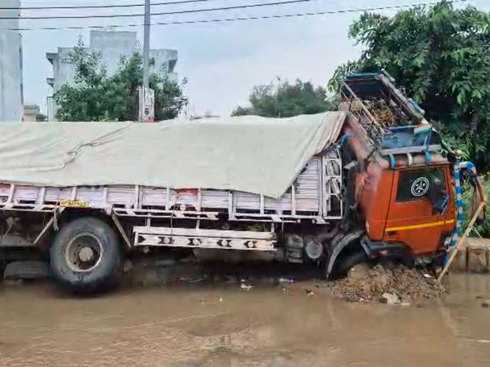 Haryana: Cement-laden truck sinks into waterlogged road in Gurugram's Sector 9 following heavy rain (Photo/ANI) Haryana: Cement-laden truck sinks into waterlogged road in Gurugram's Sector 9 following heavy rain (Photo/ANI)