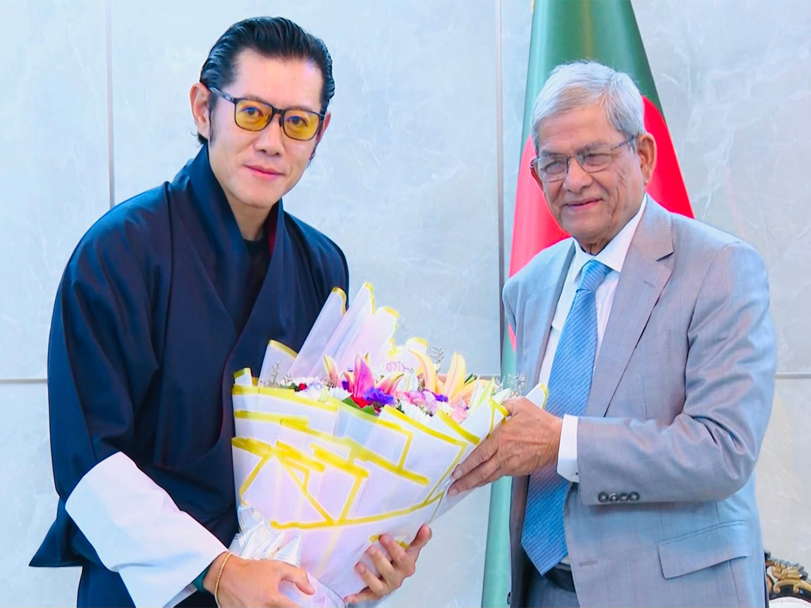 Bangladesh President Mirza Fakhrul Islam Alamgir greets Bhutanese King Jigme Khesar Namgyel Wangchuck with a bouquet at Dhaka airport on Wednesday. (Image Source: Bangabhaban, the Presidential Palace of Bangladesh)