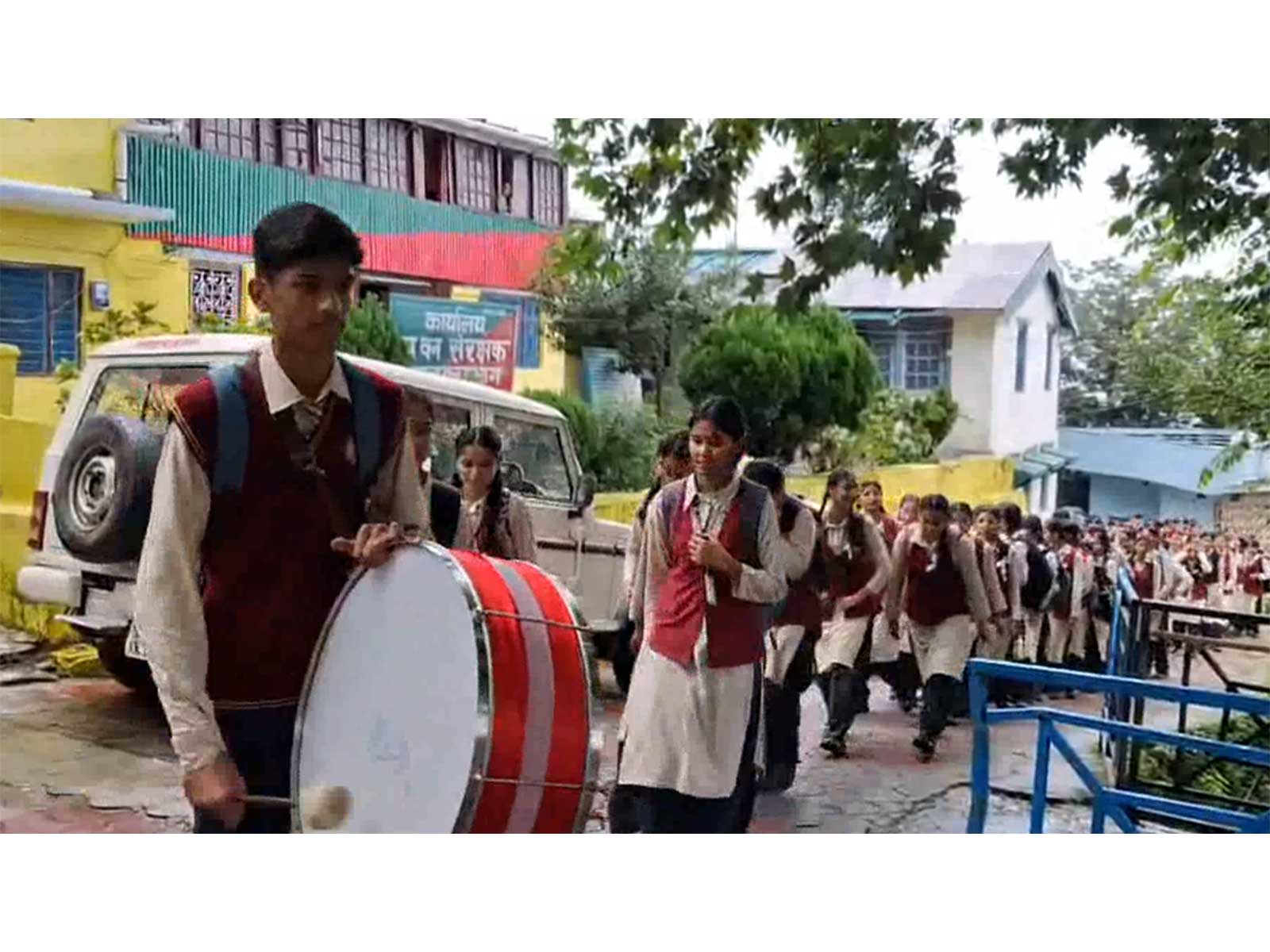 Student playing drums outside DFO office in Pauri Garhwal (Photo/ANI)