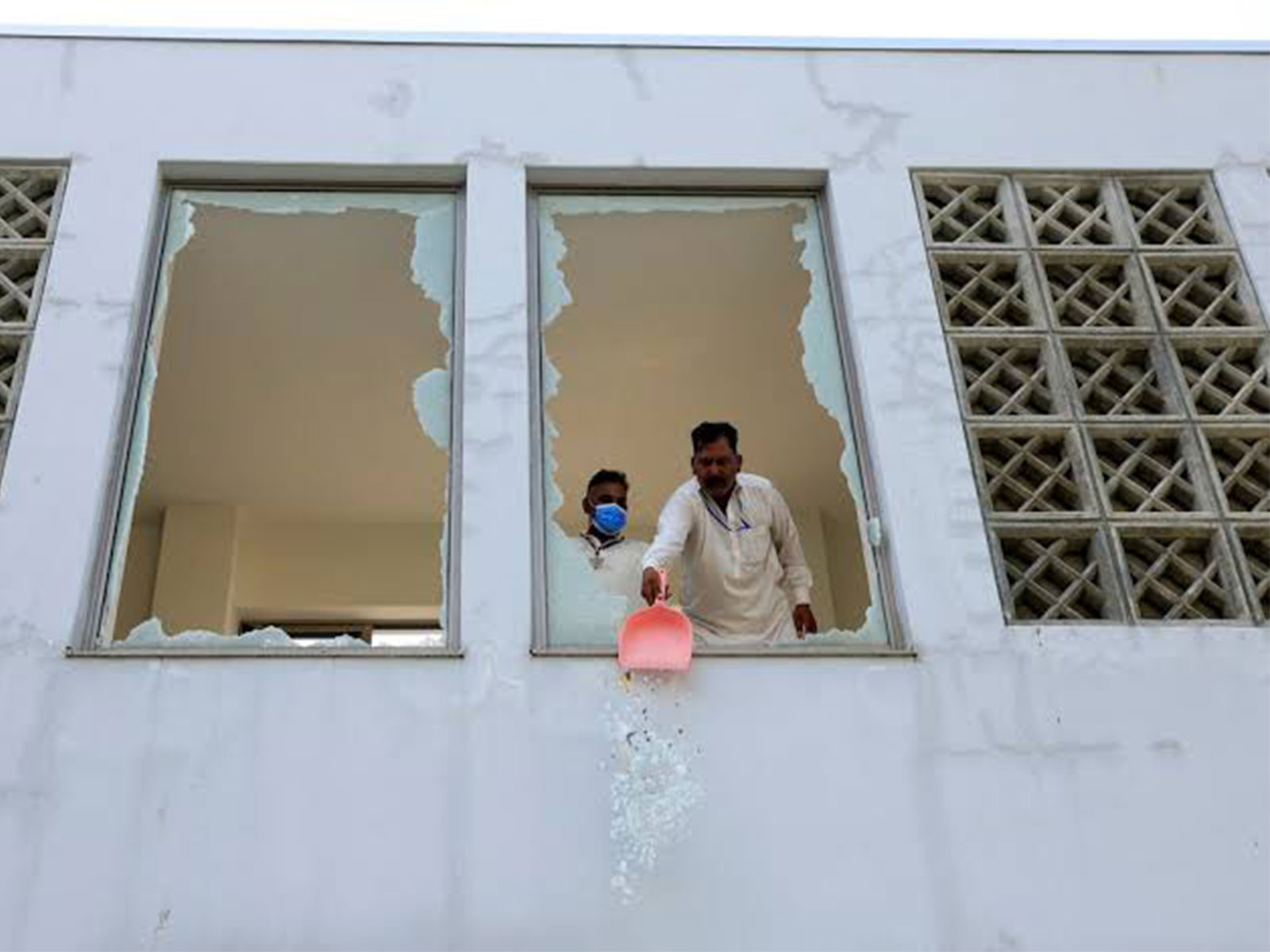 A worker clears shattered glass from a window following a fire at the Pakistan Institute of Medical Sciences (PIMS) hospital in Islamabad, Pakistan. (File Photo/Reuters)