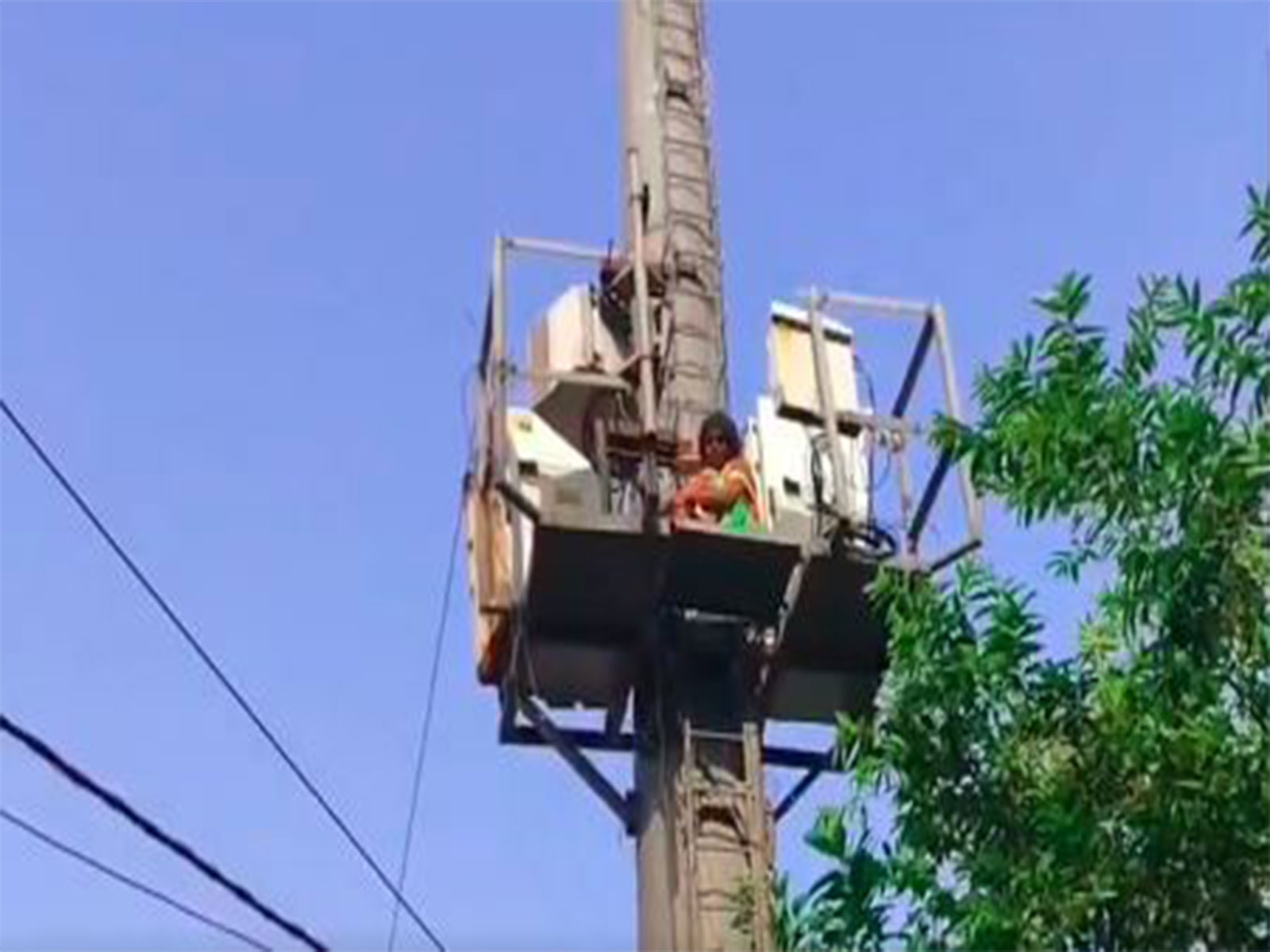 A woman on a tower on Hazratganj's Park Road (Photo/ANI)