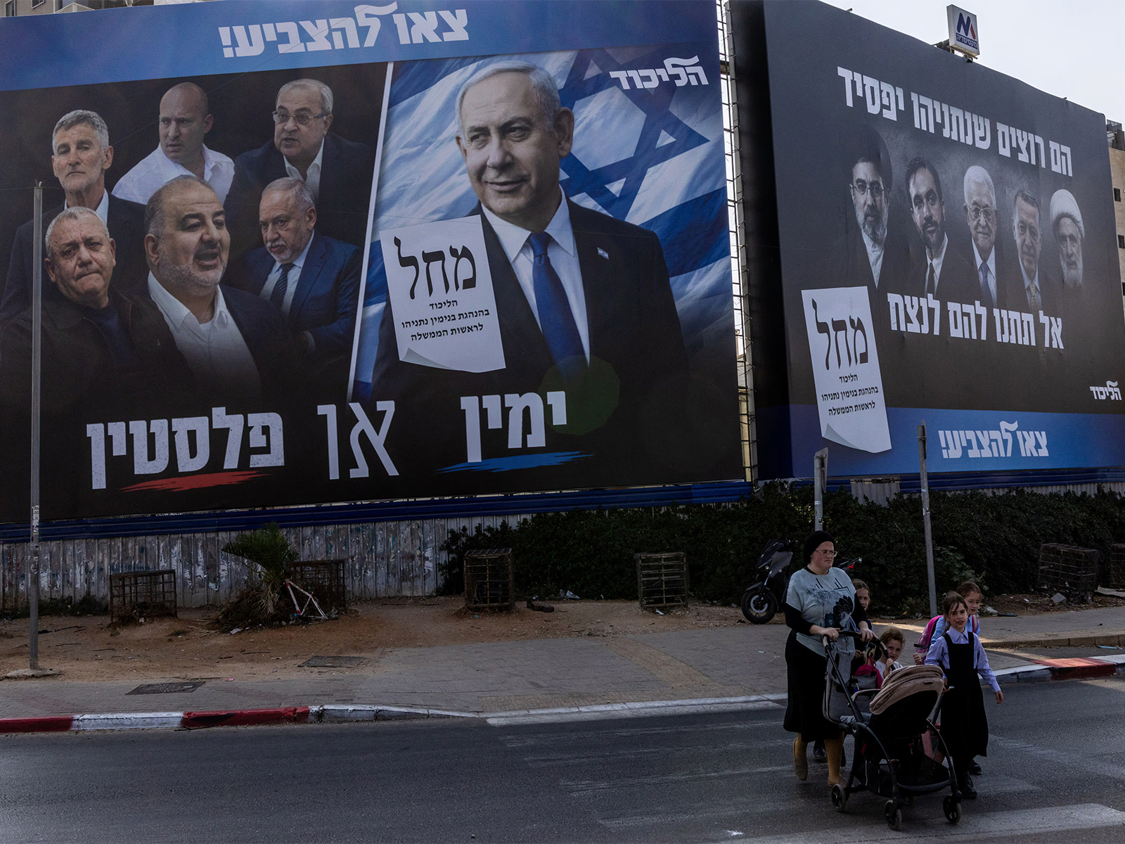 People walk next to a campaign banner of Netanyahu's Likud party in Bnei Brak, Israel. (Photo/Reuters)
